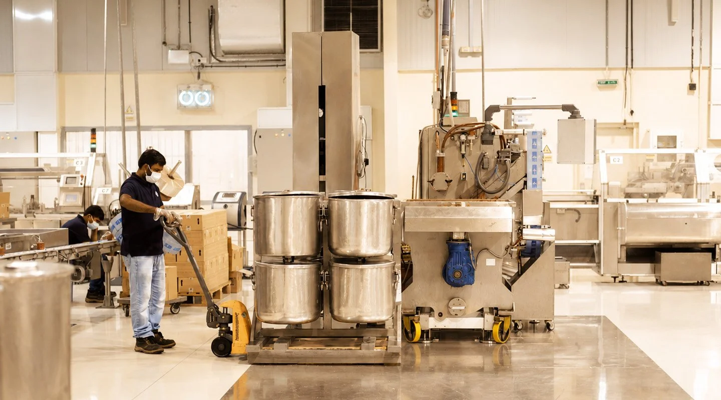 Al Fakher production facility with workers handling equipment in a clean manufacturing environment.