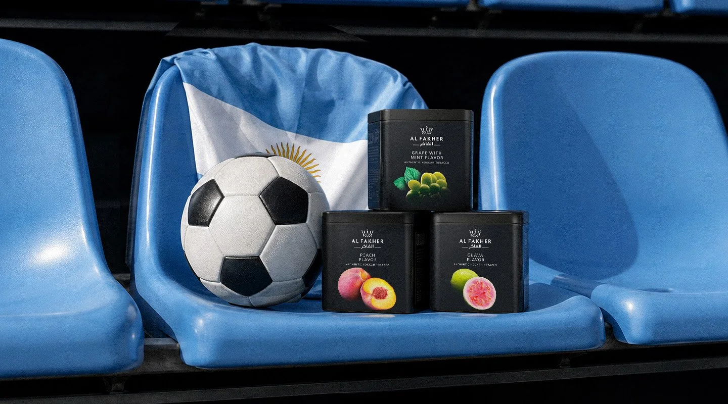 Al Fakher Grape with Mint, Peach and Guava tubs displayed beside a football and an Argentina flag on stadium seats.