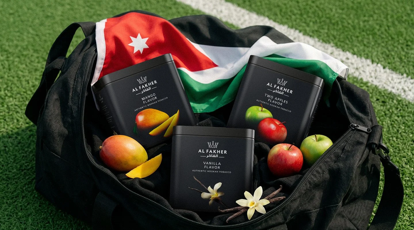 Al Fakher Mango, Two Apples and Vanilla tubs displayed in a sports bag with a Jordanian flag and fresh fruit.