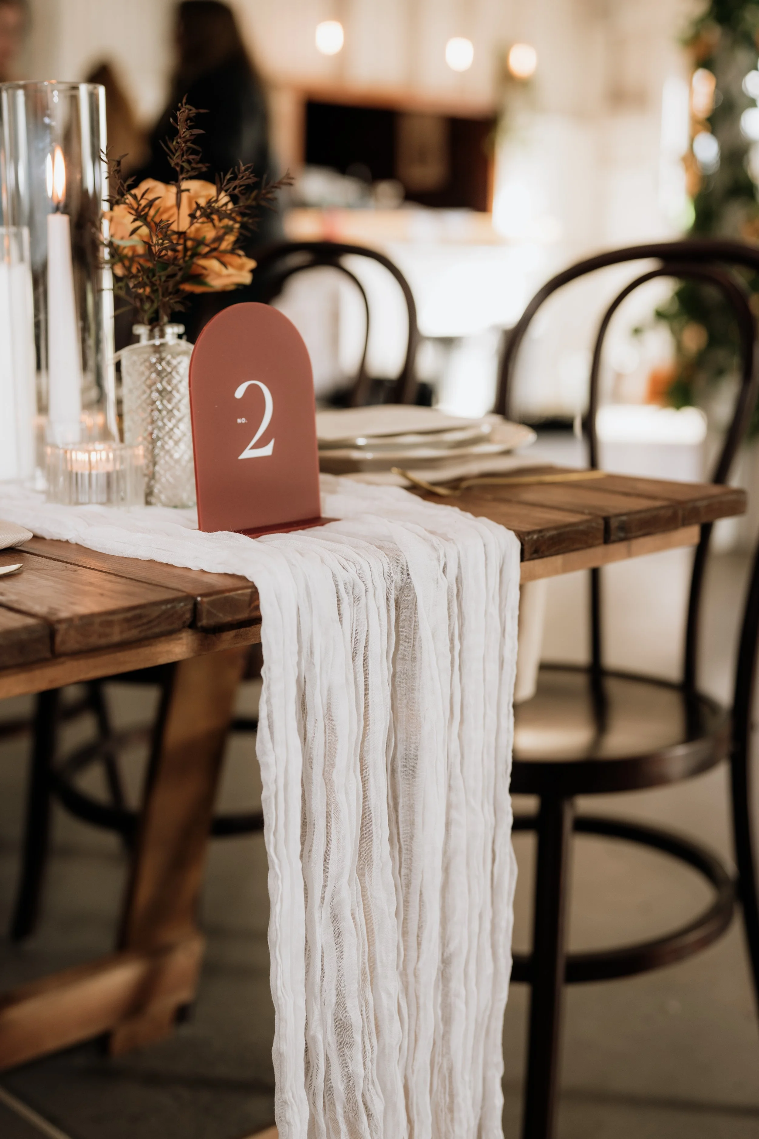 Three different sized pillar candles sit in groups of three surrounded by gum leaves