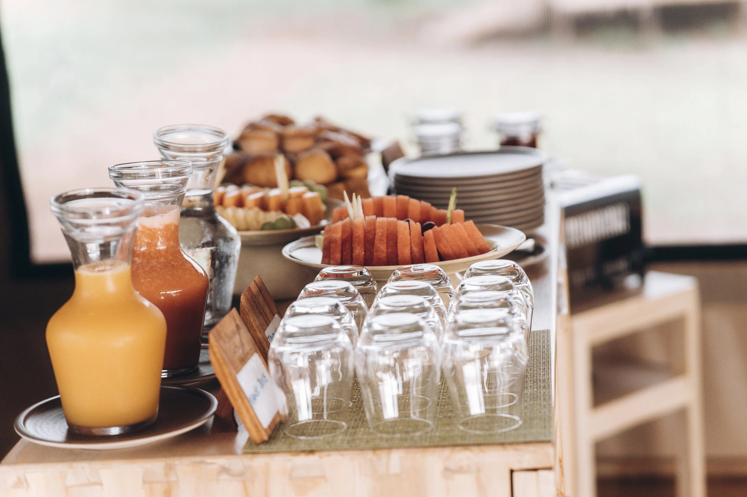 French press coffee with cups and jar served in a wicker tray at a luxury safari lodge, overlooking the African wilderness.