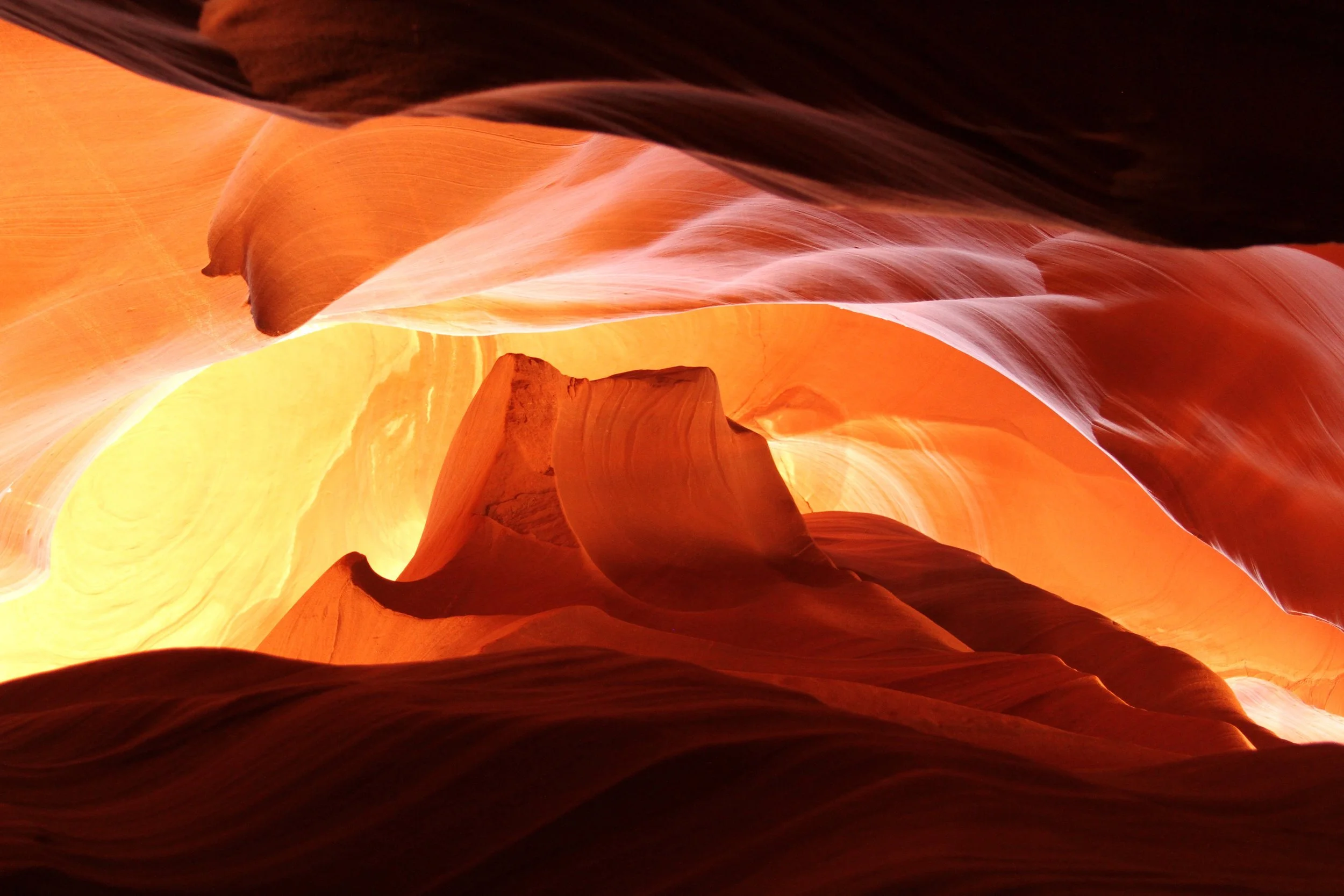 Interior view of Antelope Canyon with glowing orange and yellow sandstone walls.