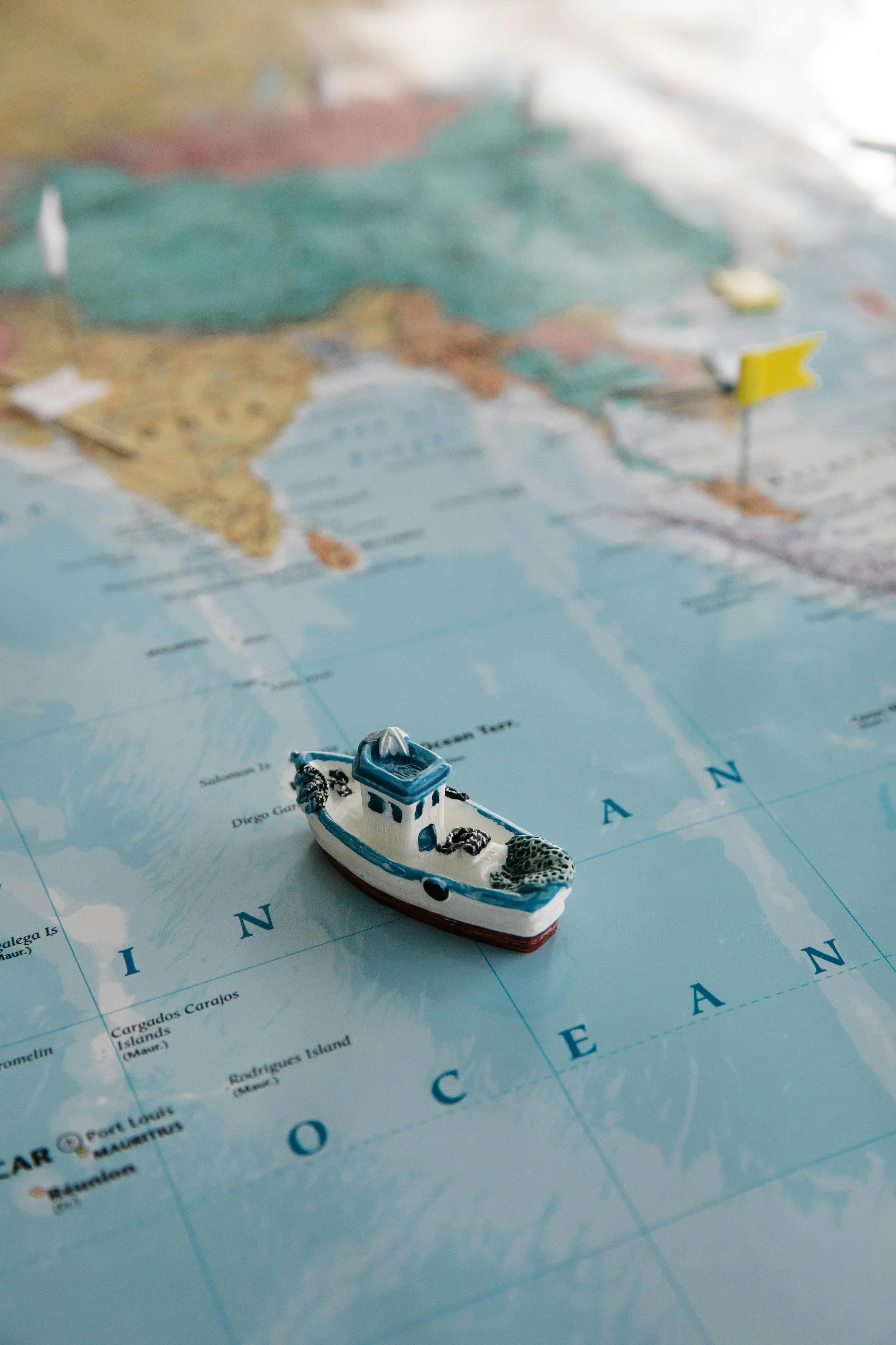 A miniature boat placed on a world map showing the Atlantic Ocean.