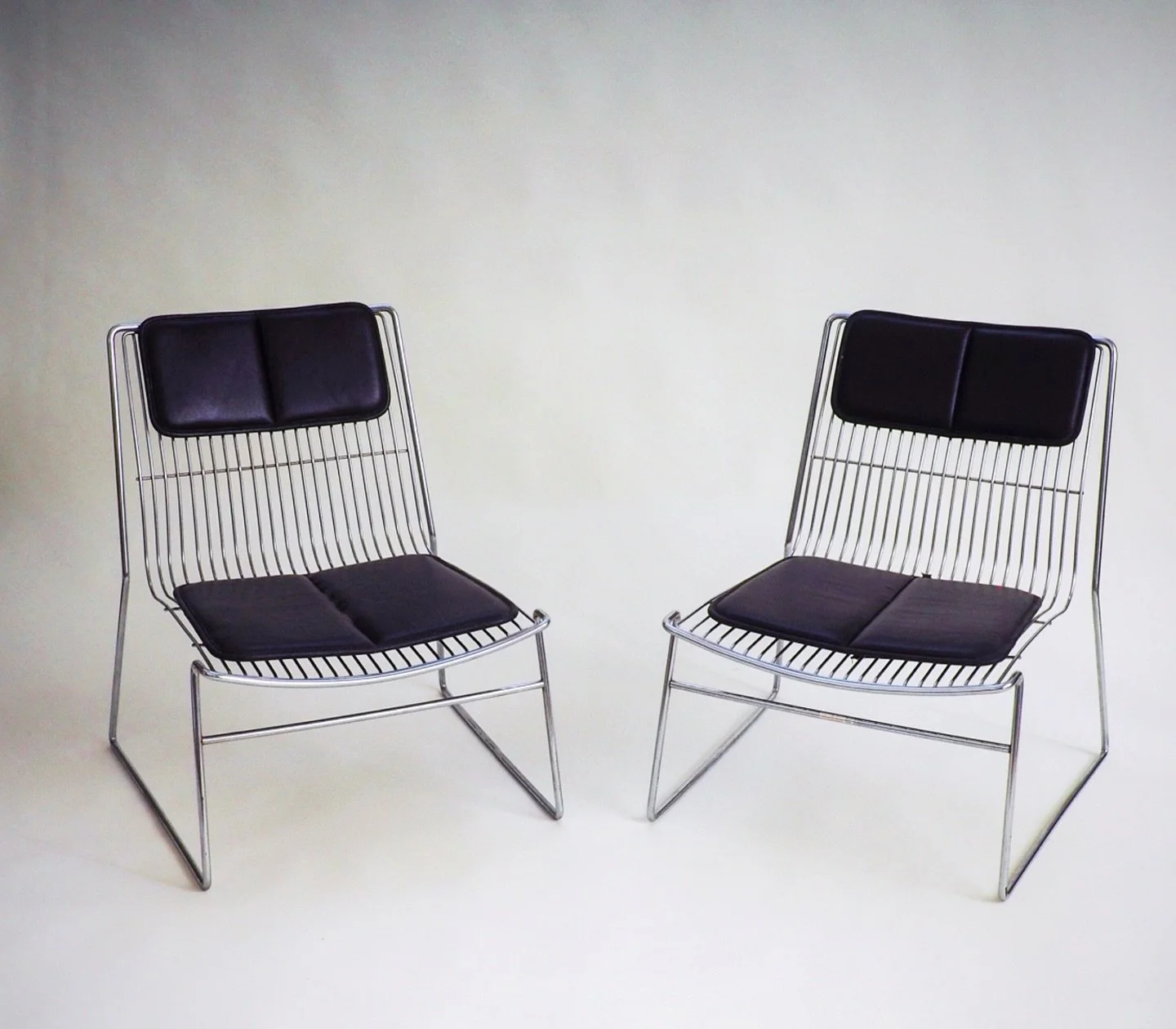 Set of 2 Wire Lounge Chairs

Striking pair of postmodern wire lounge chairs. The chrome wire structure is covered with removable brown skai back and seat cushions. Their sleek, chrome-plated steel frames create a clean, architectural silhouette. Thes