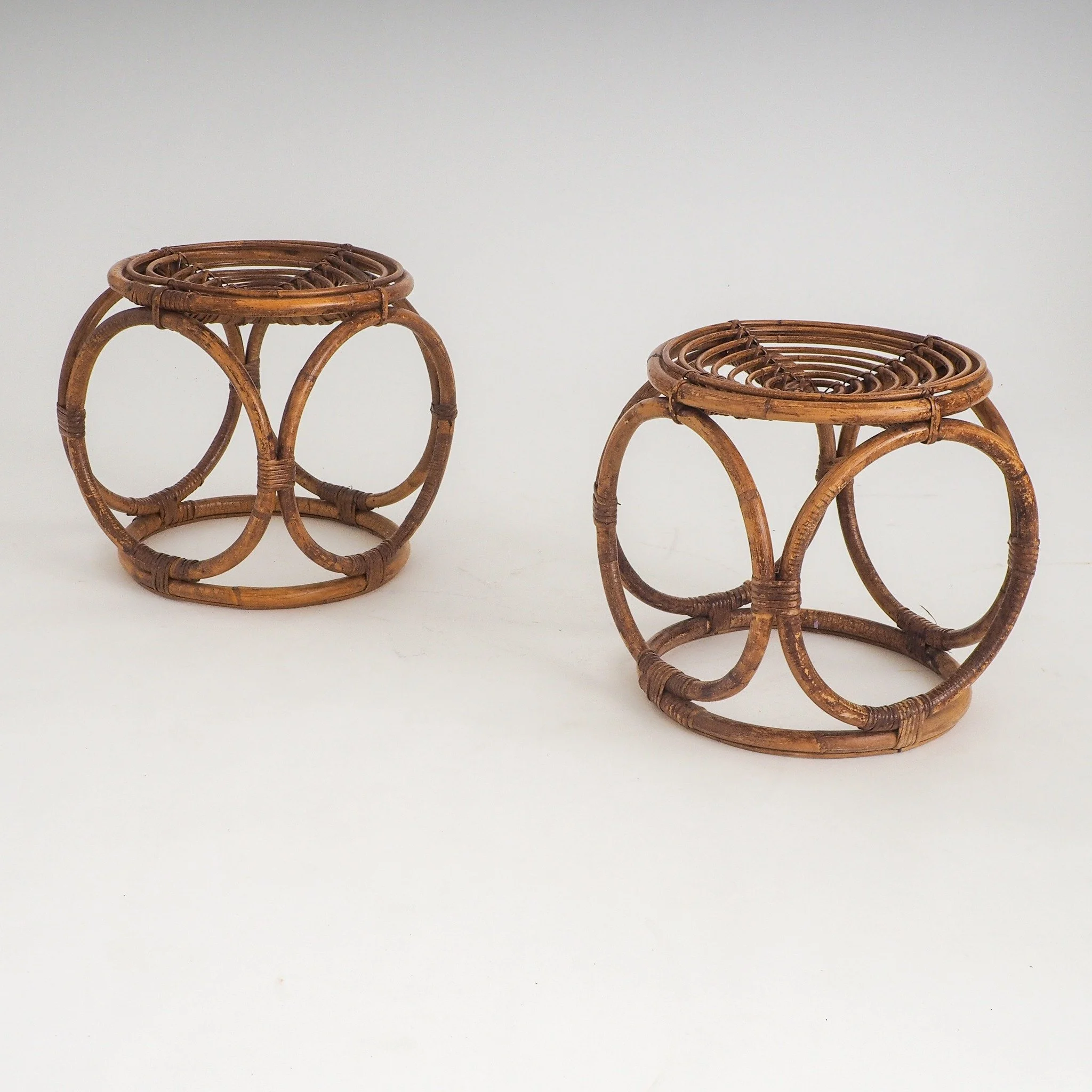 Pair of Vintage Handcrafted Rattan Stools / Side Tables

A matching pair of vintage bent rattan stools. These versatile pieces double  as side tables or accent plant stands. Each stool highlights a concentric circular seat  bound with traditional can