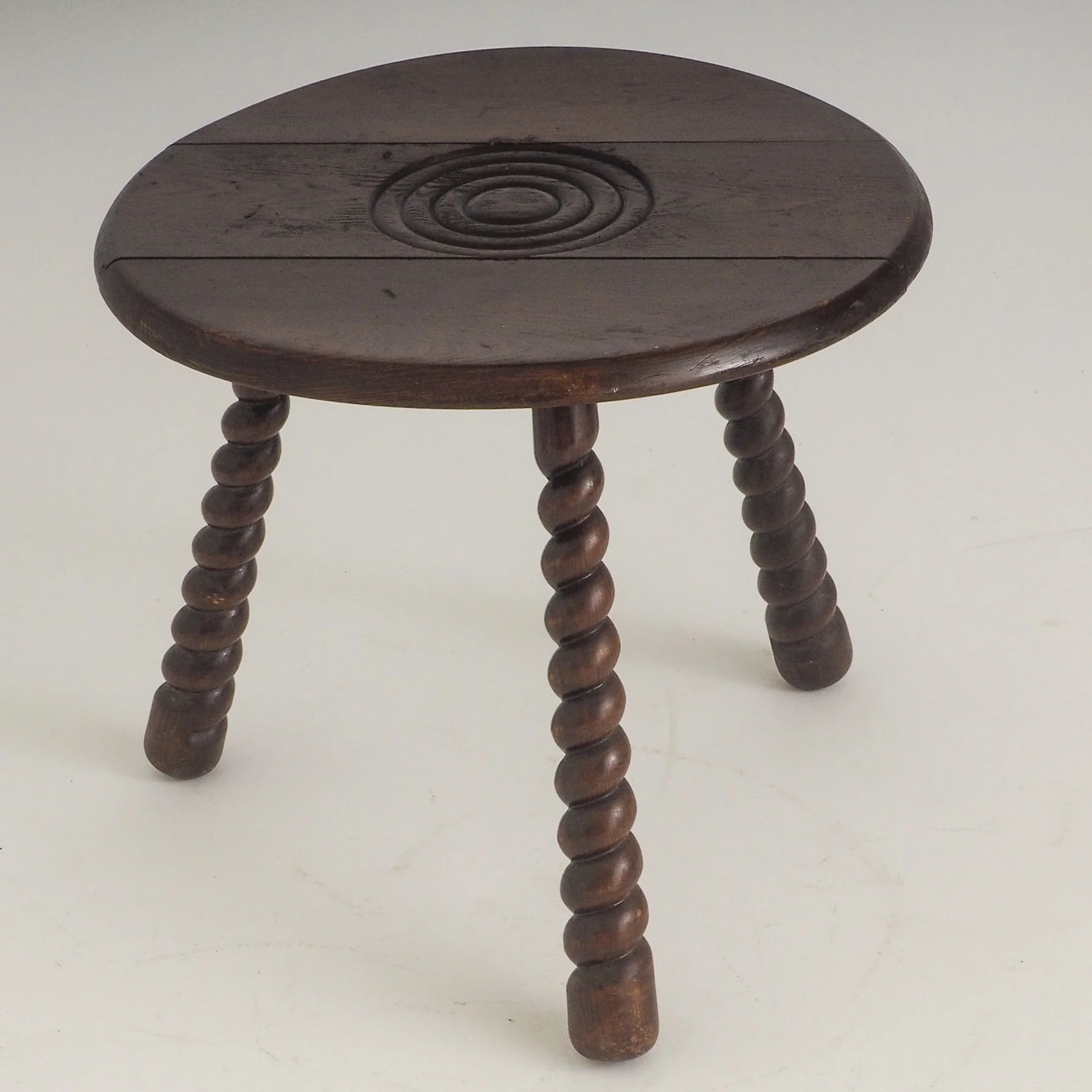 French Oak Tripod Side Table Attributed to Charles Dudouyt

French wooden tripod side table with turned bobbin legs and concentric carved top attributed to Charles Dudouyt and produced in the 1940-50s. 
Crafted from solid oak wood, the round surface 