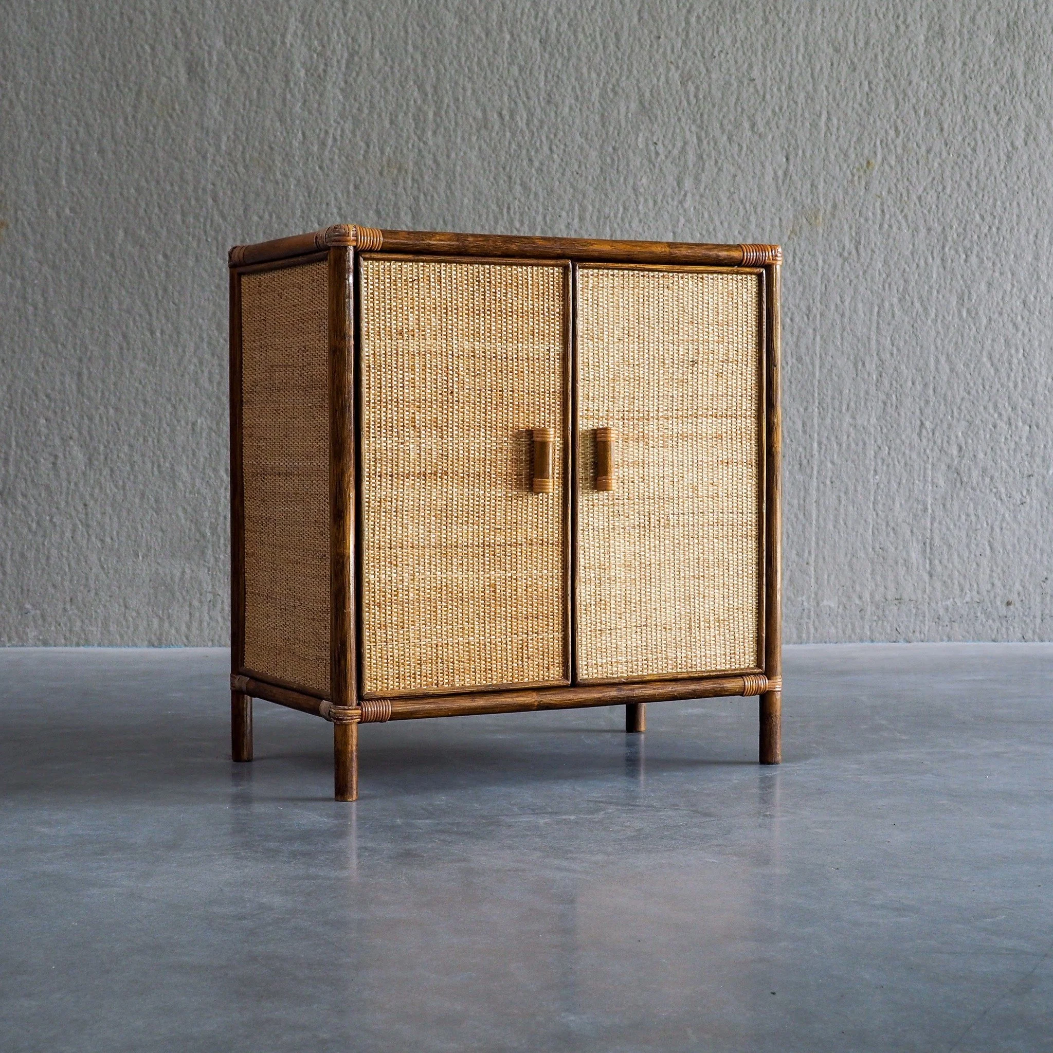 Vintage Rattan &amp; Woven Cane Cabinet with 2 doors

Versatile vintage accent cabinet, crafted with a rich dark rattan framework and finely woven light cane paneling. Featuring a double-door design, decorative bamboo-style handles, and light cane wr