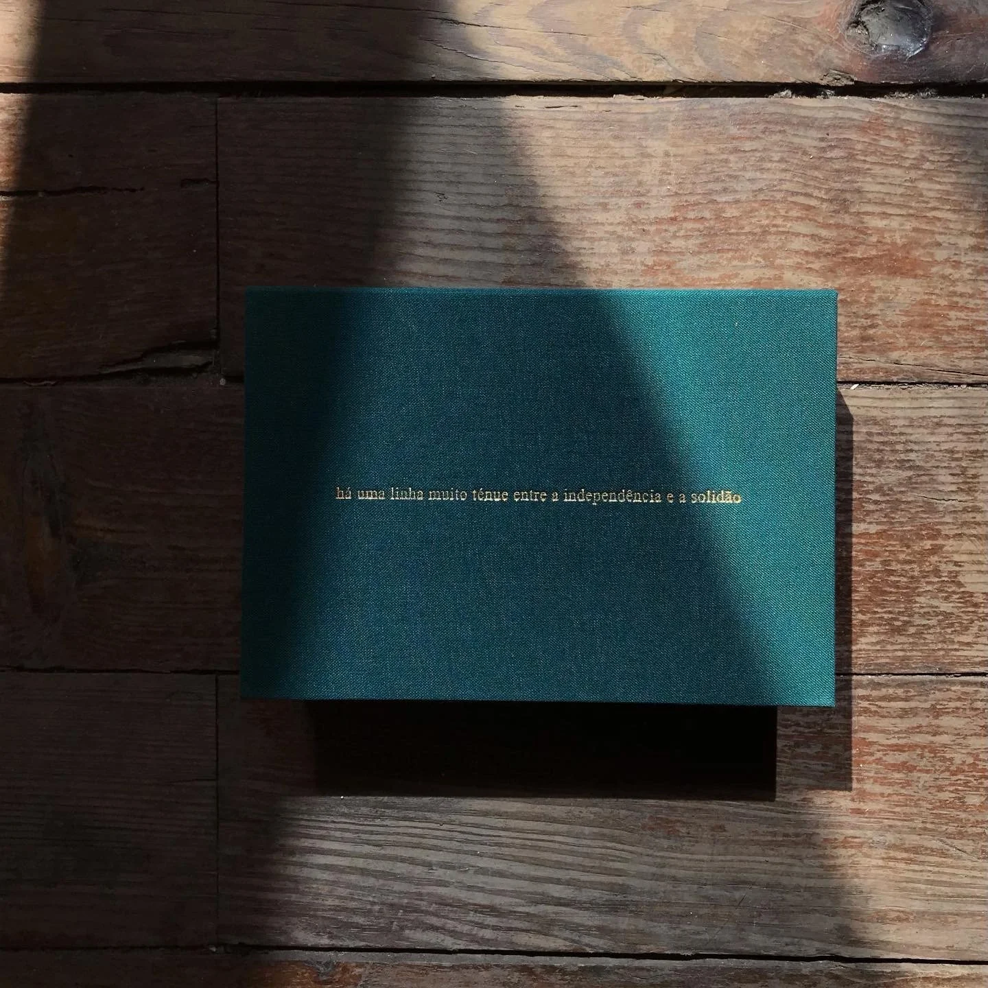 green fabric box with phrase/title engraved in gold on top