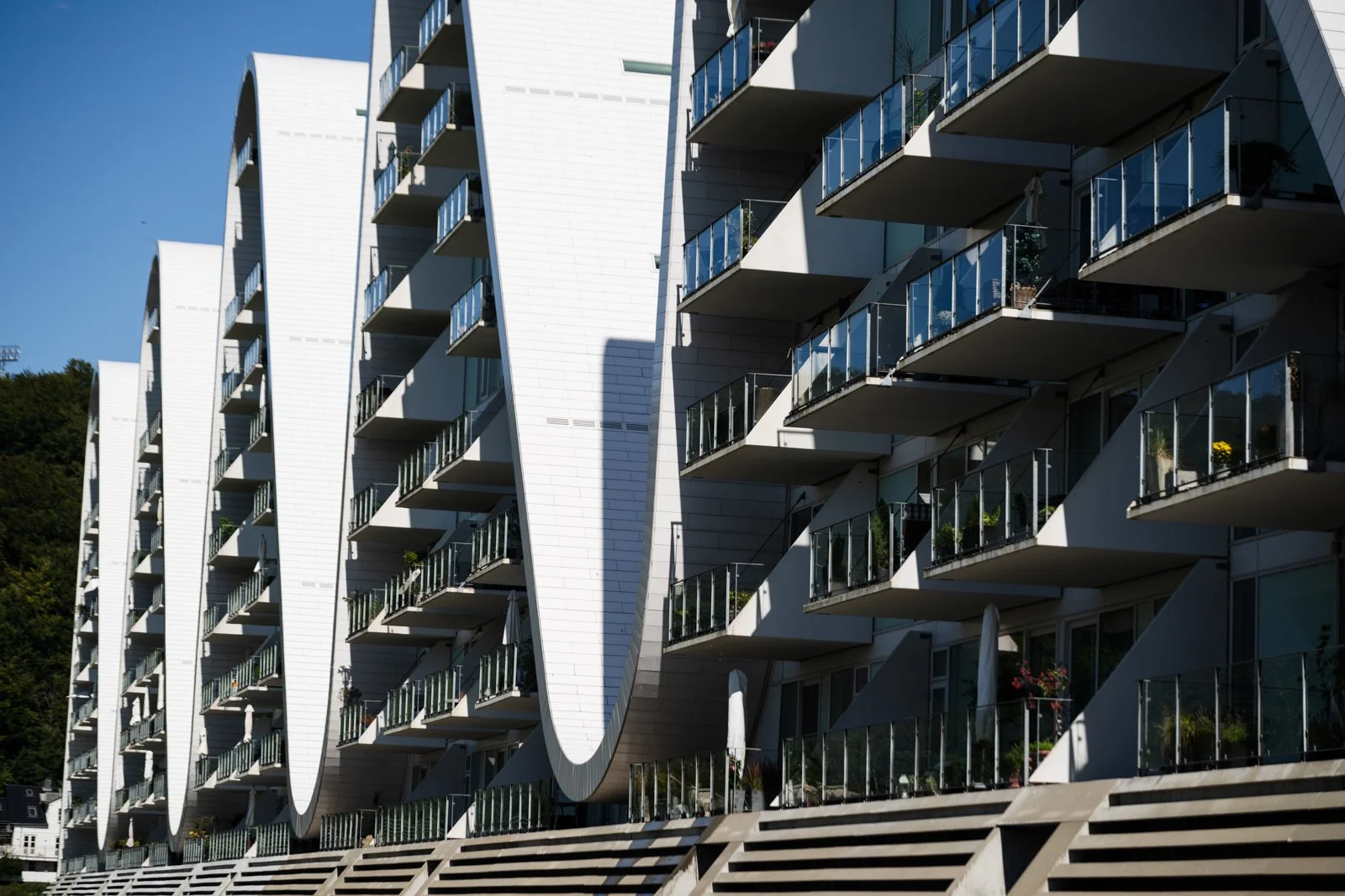 Detailed shot of The Wave's individual apartment balconies, showcasing the rhythmic repetition and the structure's functional facade.
