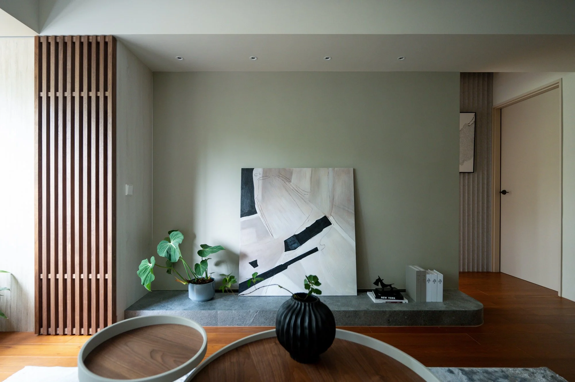 思沐設計によるリビング。従来のテレビボードを薄い石材ベースで代替。余白を活かし、簡潔な装飾でノイズレスな極上ミニマルな空間美を追求。