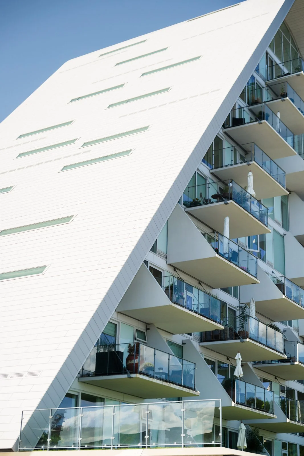 Side detail of The Wave's structure, highlighting the curved shell and the rhythmic layering of individual apartment balconies.
