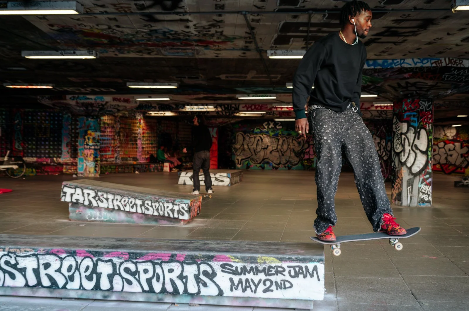 A person riding a skateboard at a graffiti-covered skate park.