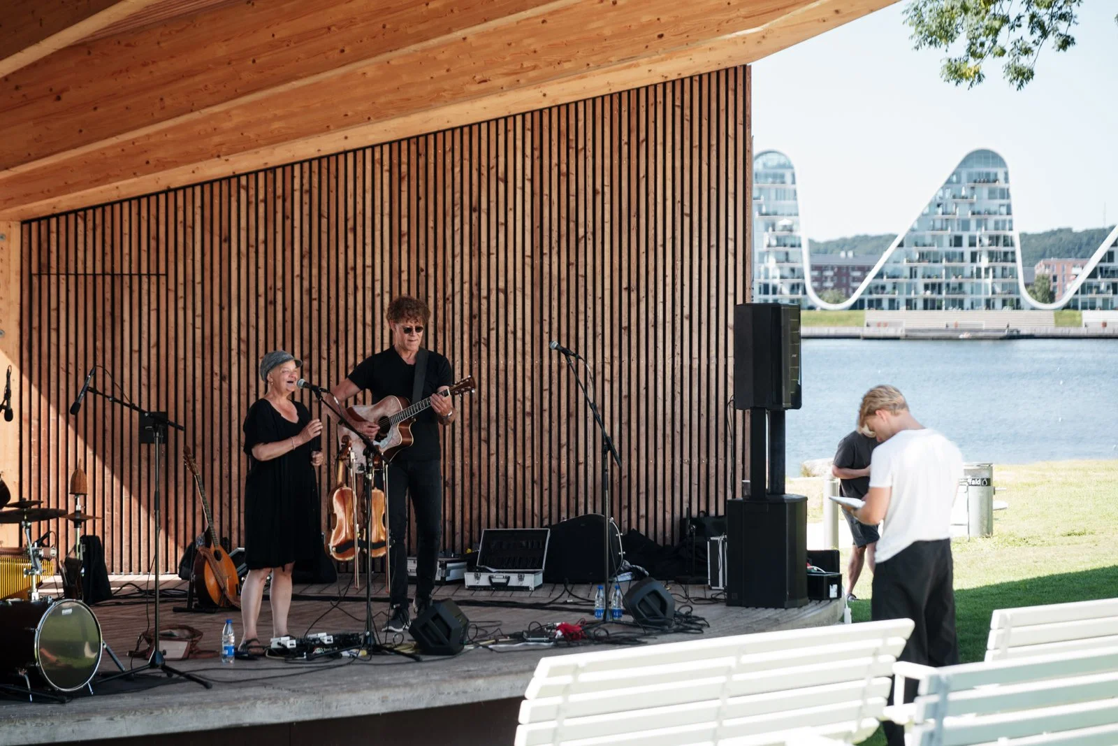 Live performance on the outdoor wooden stage, using the striking architecture as a dramatic backdrop.
