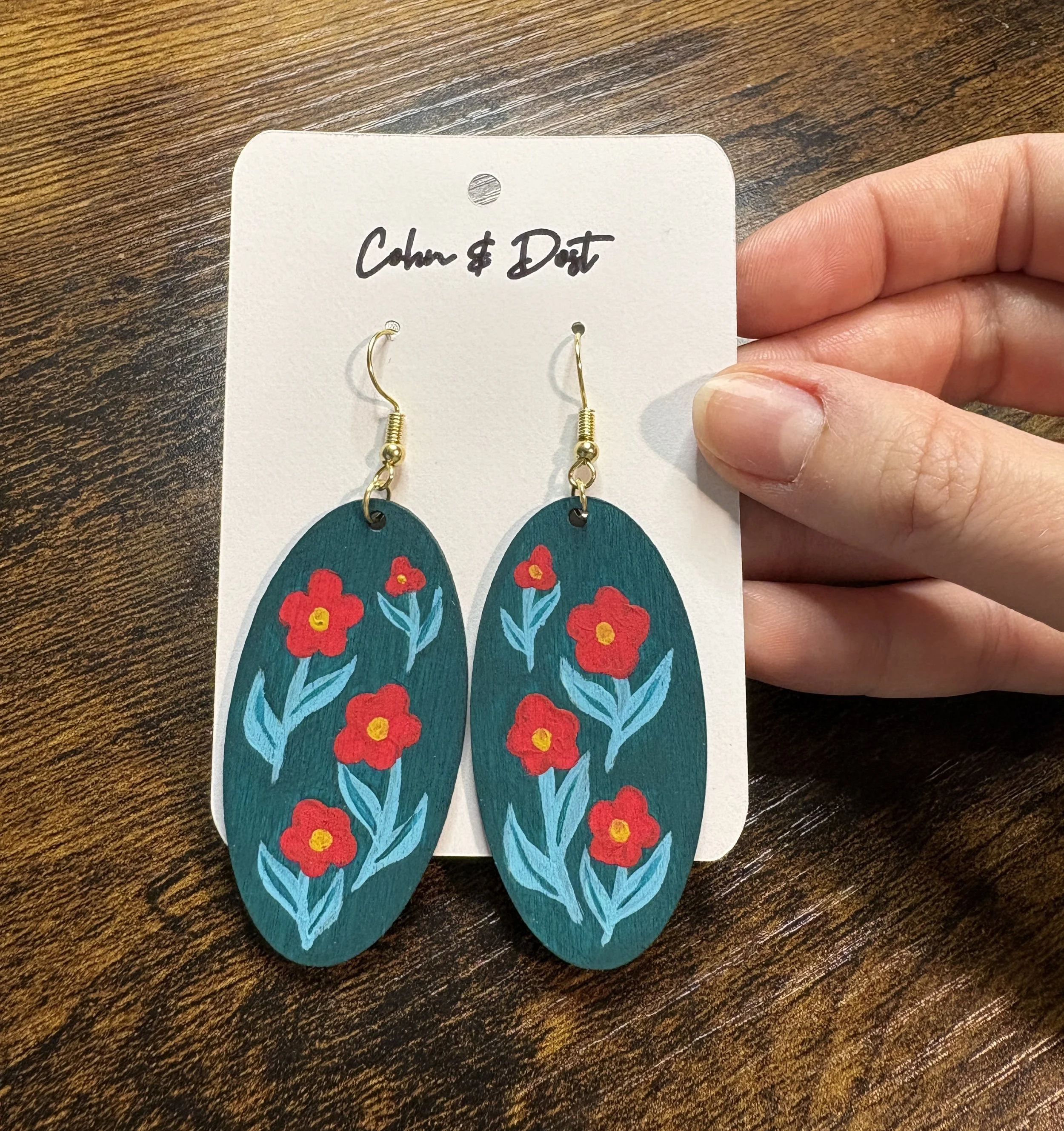 teal oval earring holding.JPG