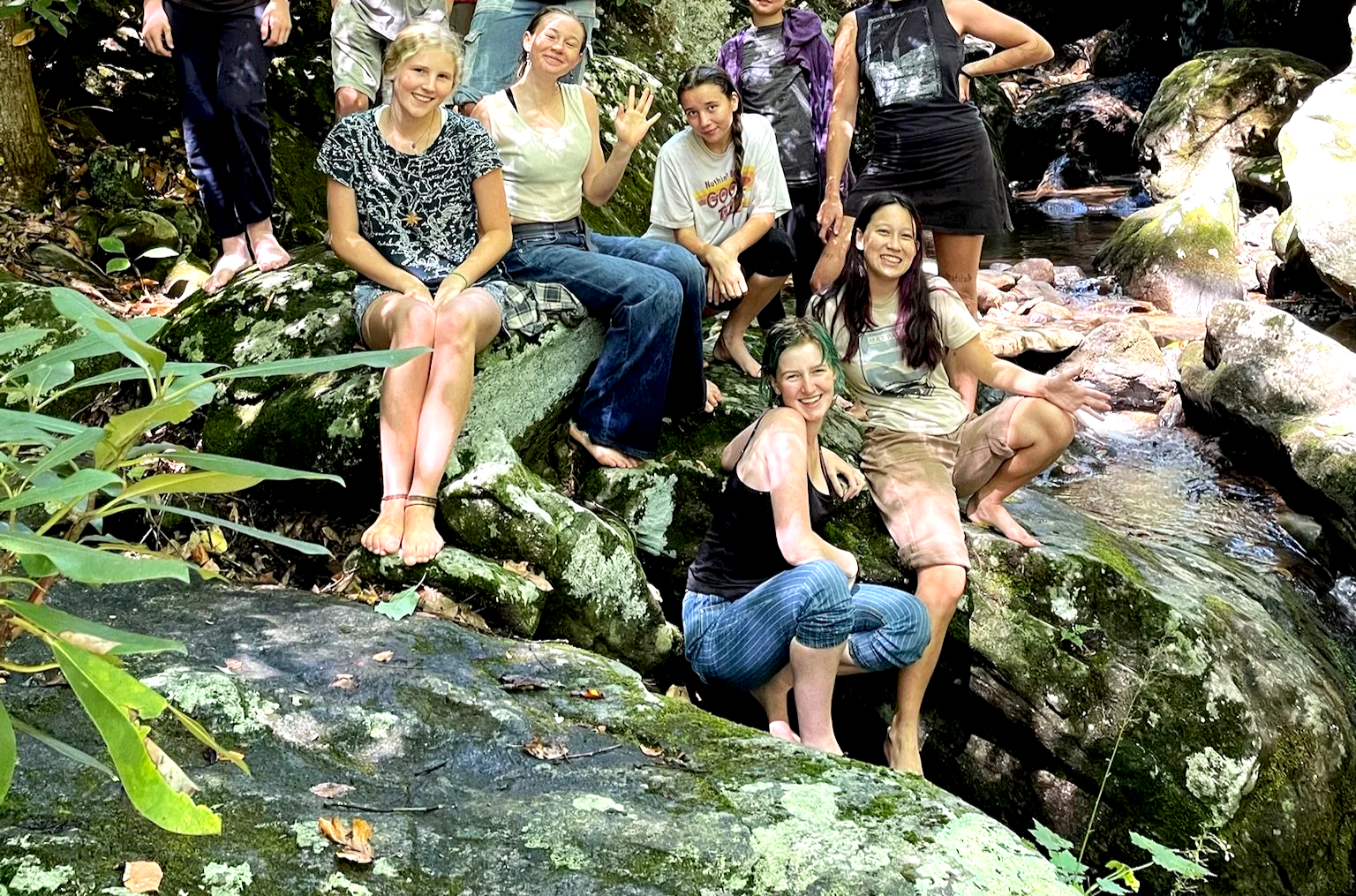 Teens laugh together after spending the day outside splashing in a creek at a screen-free outdoor camp near Asheville, NC.