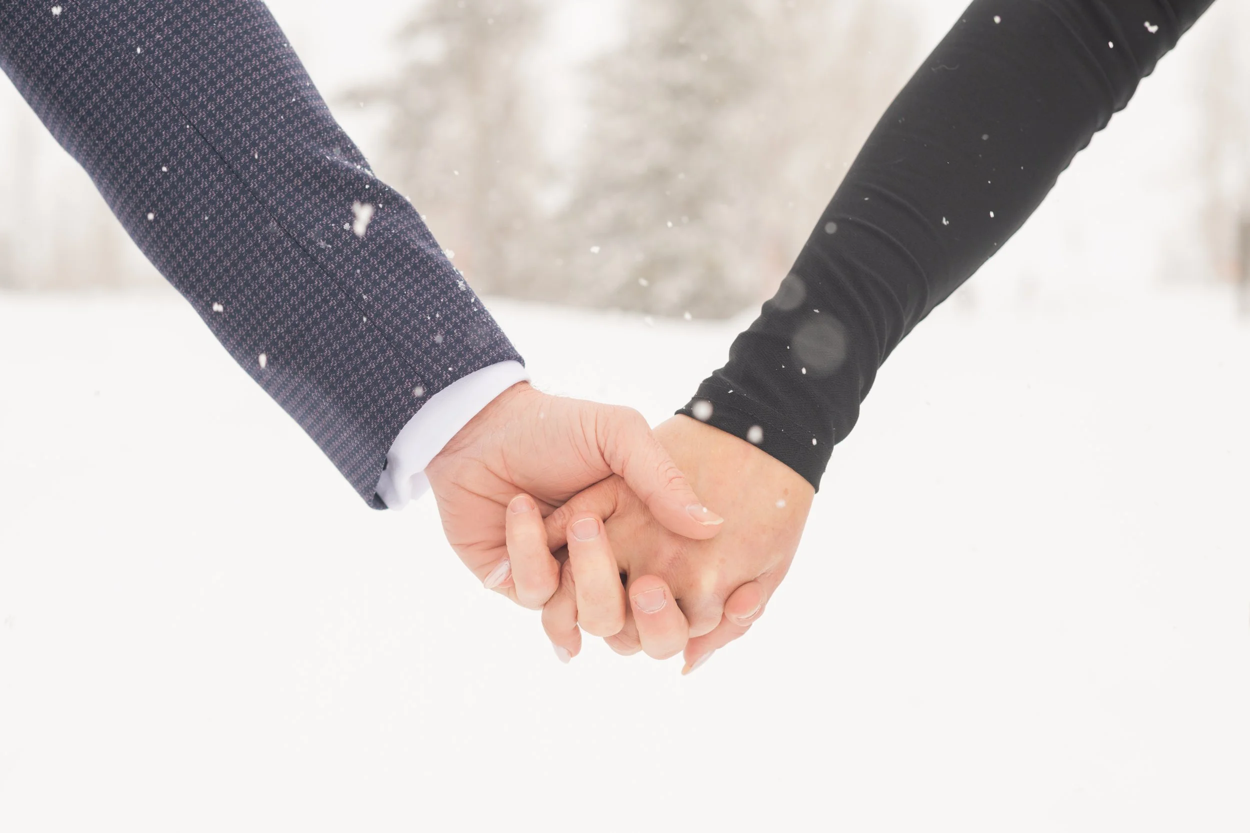 couple holding hands in the snow