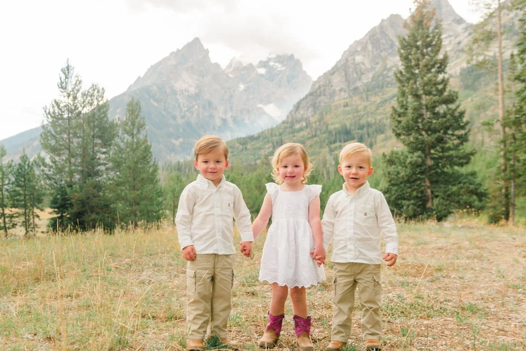 three young kids holding hands and smiling