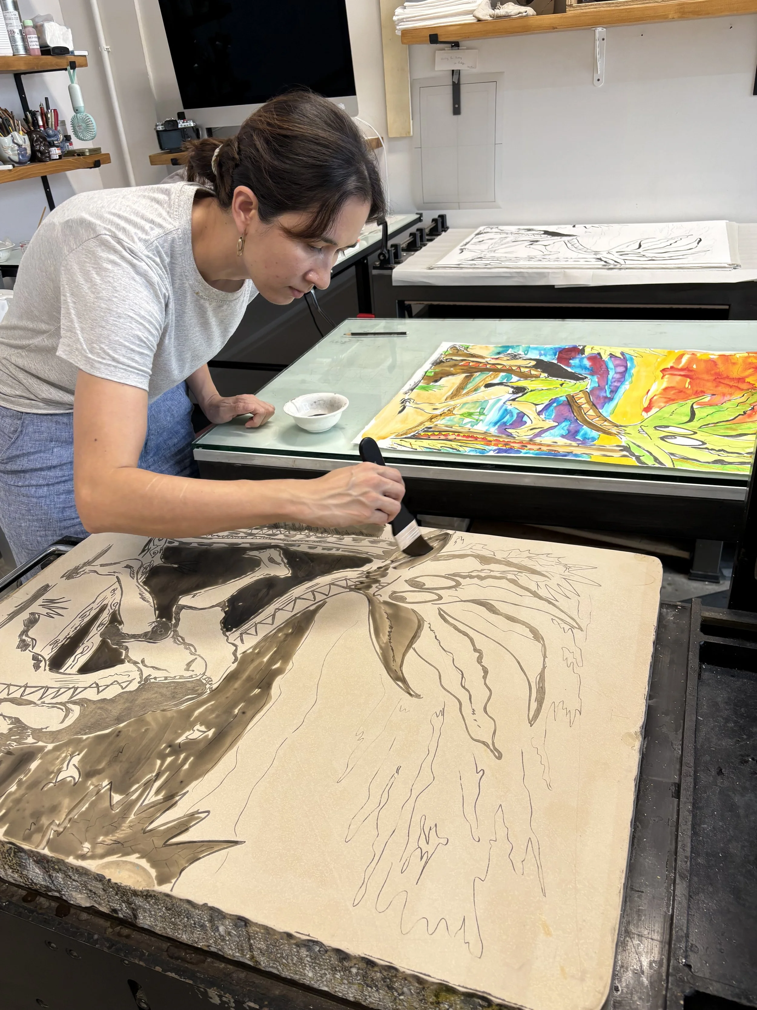 An artist painting a colorful landscape on a large canvas featuring a dragon and a sunset.