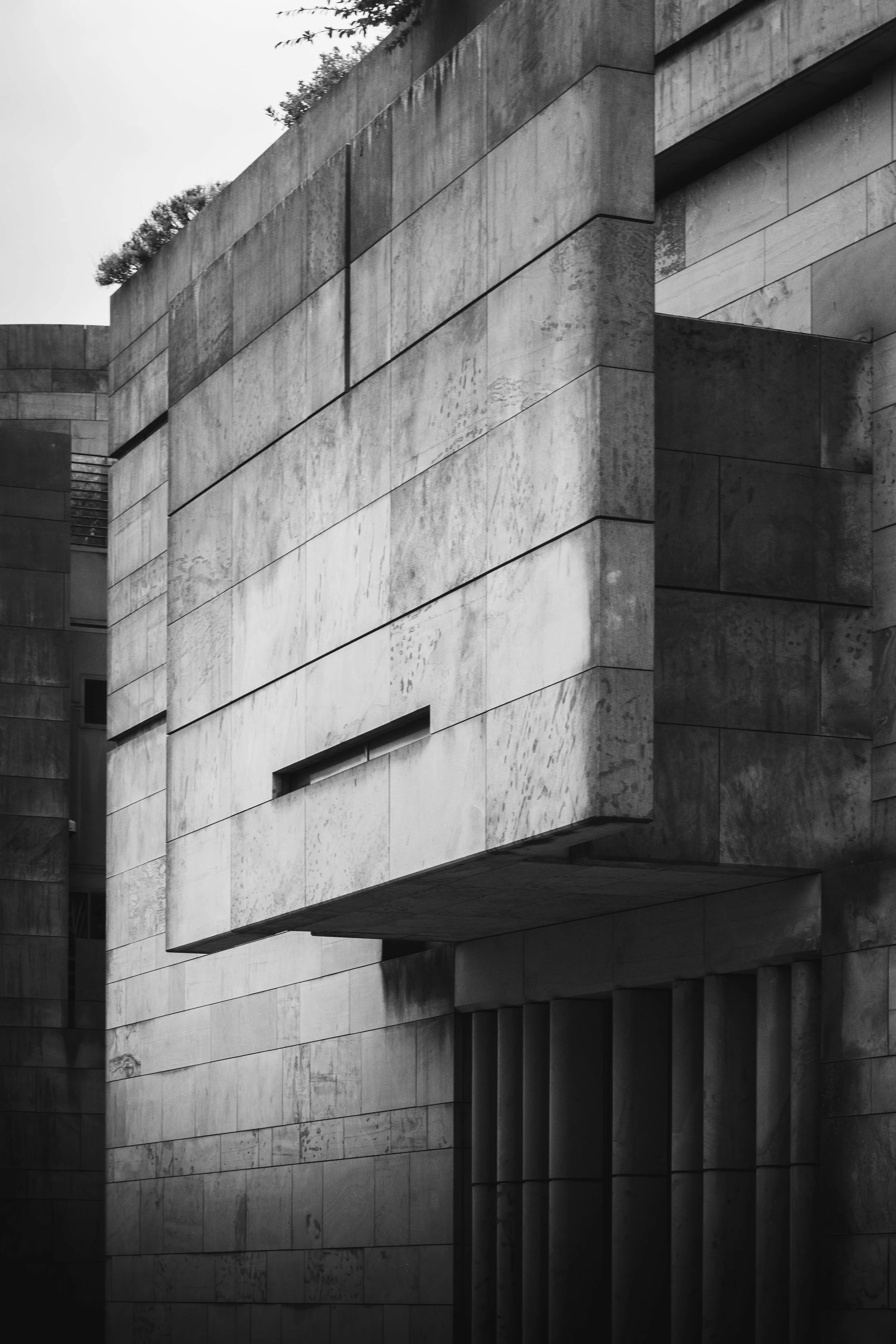 Close-up view of a modern building's exterior with large, textured concrete blocks arranged in clean, geometric patterns.