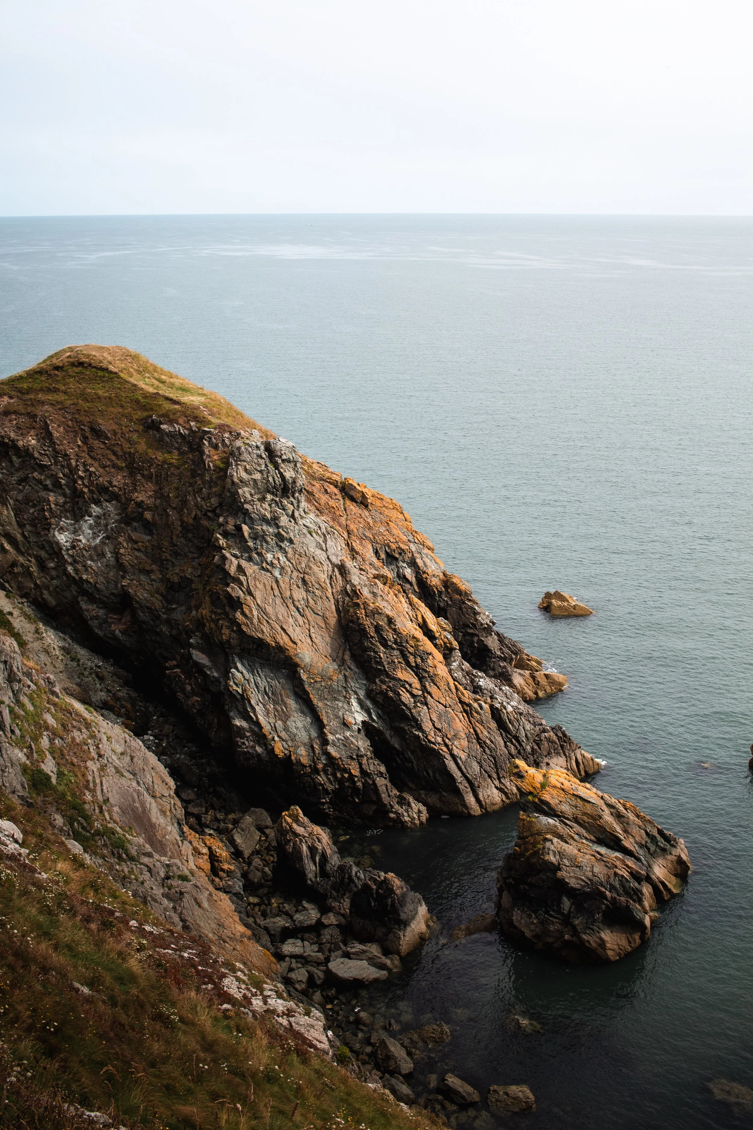 Cliffside view of rocky coastline with the ocean in the background