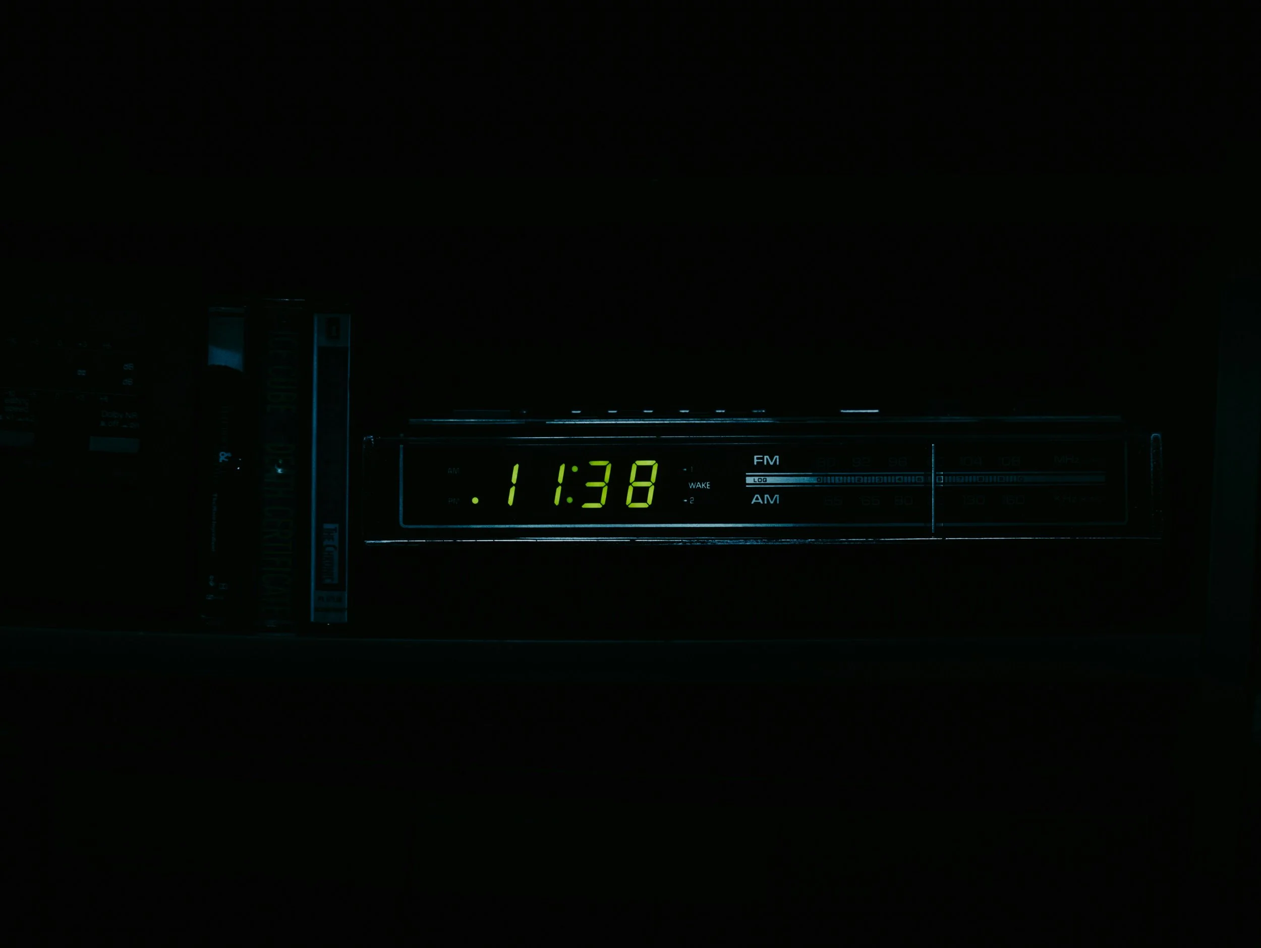 Digital alarm clock displaying the time 11:38, with a dark background indicating a perimenopausal woman's sleepless nights.