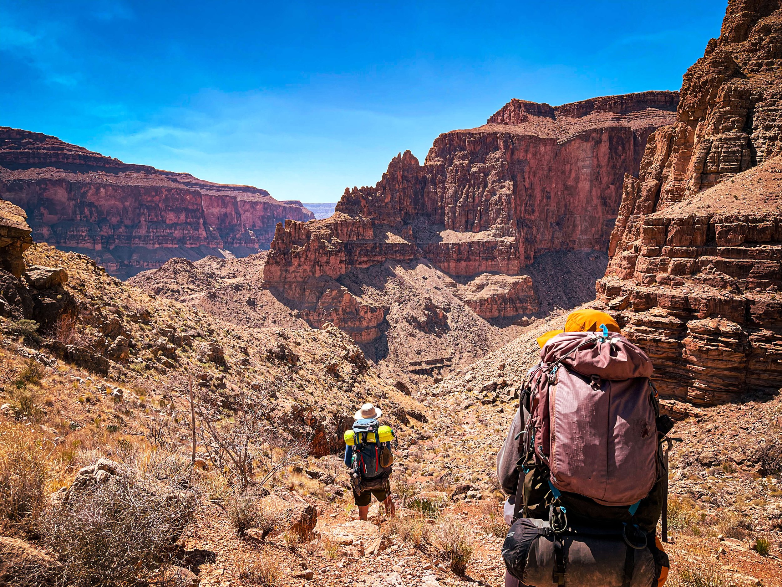 2 backpackers descend the remote north rim Bill Hall Trail, Deer Creek Loop Trail, Grand Canyon National Park, Arizona, USA, American Southwest, backpacking, hiking, REI, camping, desert canyon, river Colorado River, north rim, remote, cliff edge, bl
