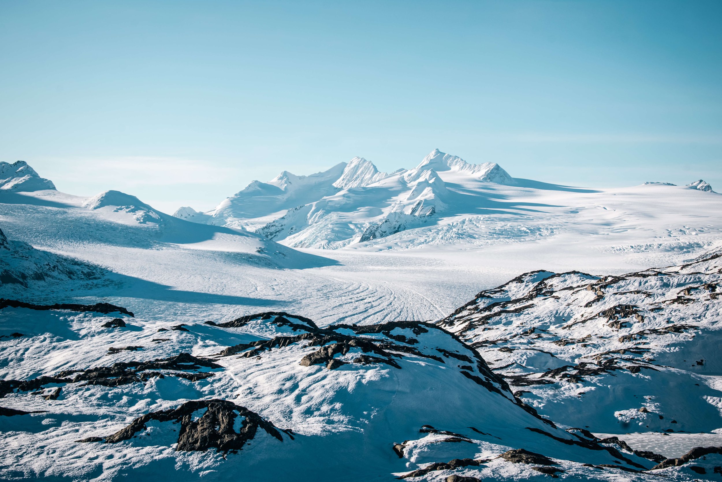 a remote mountain range in the Alaskan wilderness, taken deep in a glacial range, white frozen mountains in the foreground, snowcapped peaks in the background, Alaska, USA.