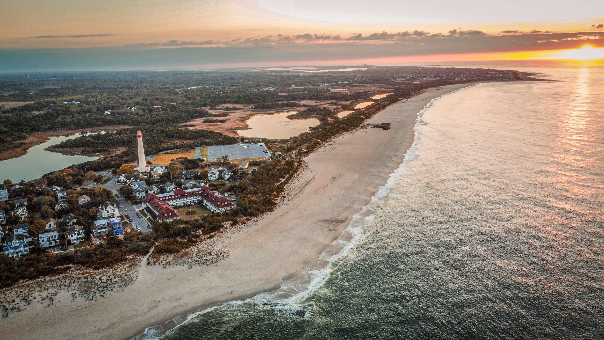 Cape May Lighthouse, Atlantic Ocean, Cape May New Jersey, USA, Cape May Point, west Cape May, orange yellow sky, sunrise, morning, drone photography, calm sea, summer, sand dunes, beach, Jersey Shore.