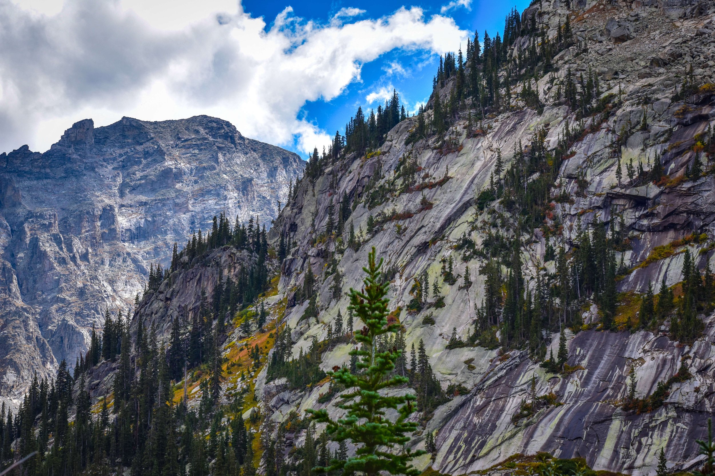 Jagged mountain peak rising in Colorado, USA, Lone Eagle Peak, Indian Peaks Wilderness, Rocky Mountains, rock face, cliff faces, blue sky and clouds, cliff edge, rock climbing, hiking, intimidating mountains, USA, Rockies.