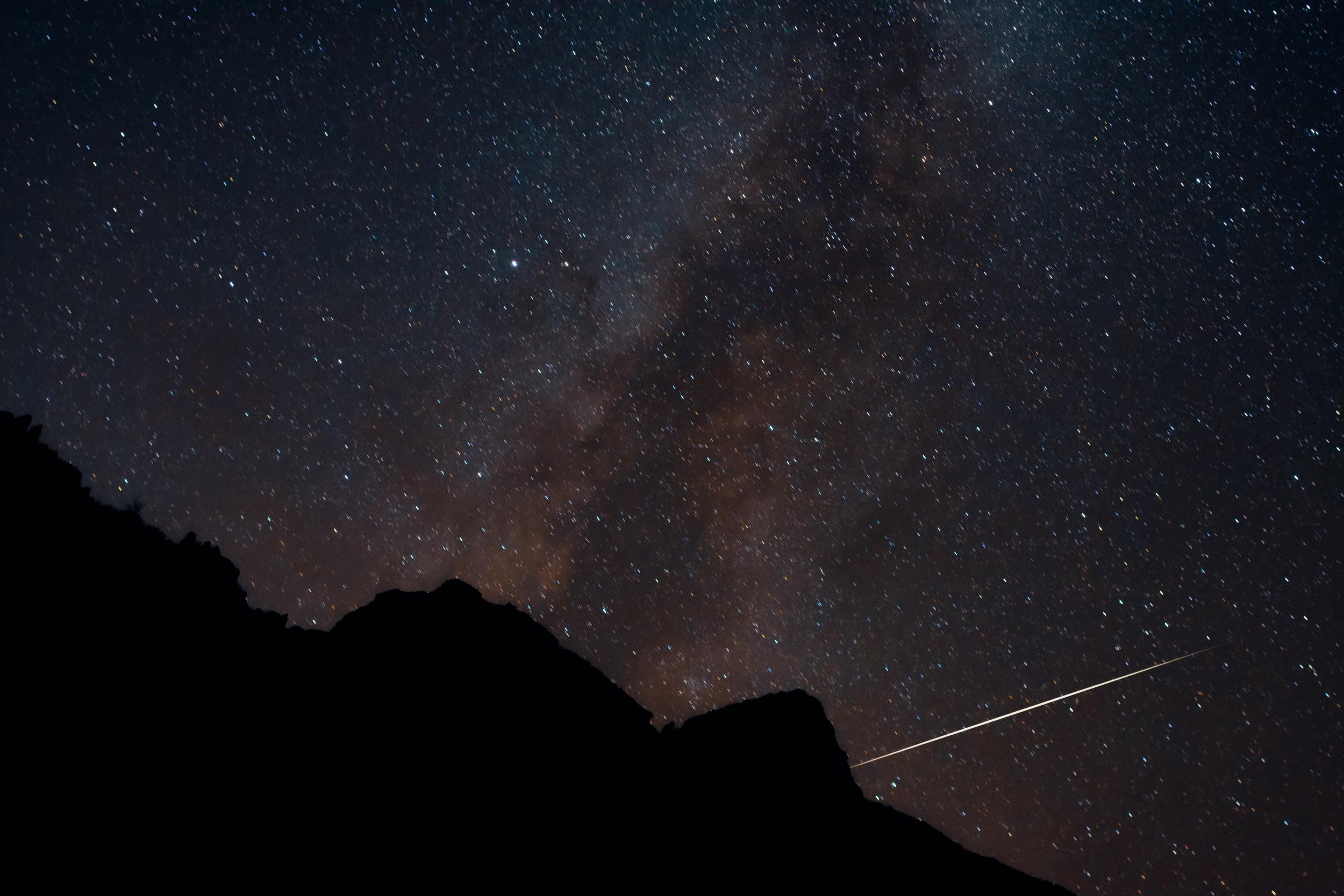 View of a shooting star and the Milky Way rising from a camp site on the shores of Hermit Rapids on the Colorado River, Grand Canyon National Park, Arizona, USA, south rim, astrophotography, river, backpacking, hiking, tent, starry night, desert, nat