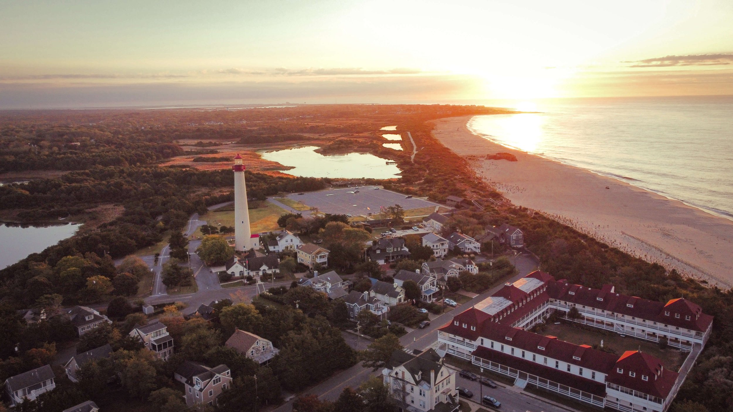Cape May Lighthouse, Atlantic Ocean, Cape May New Jersey, USA, Cape May Point, west Cape May, orange yellow sky, sunrise, morning, drone photography, calm sea, summer, sand dunes, beach, Jersey Shore.