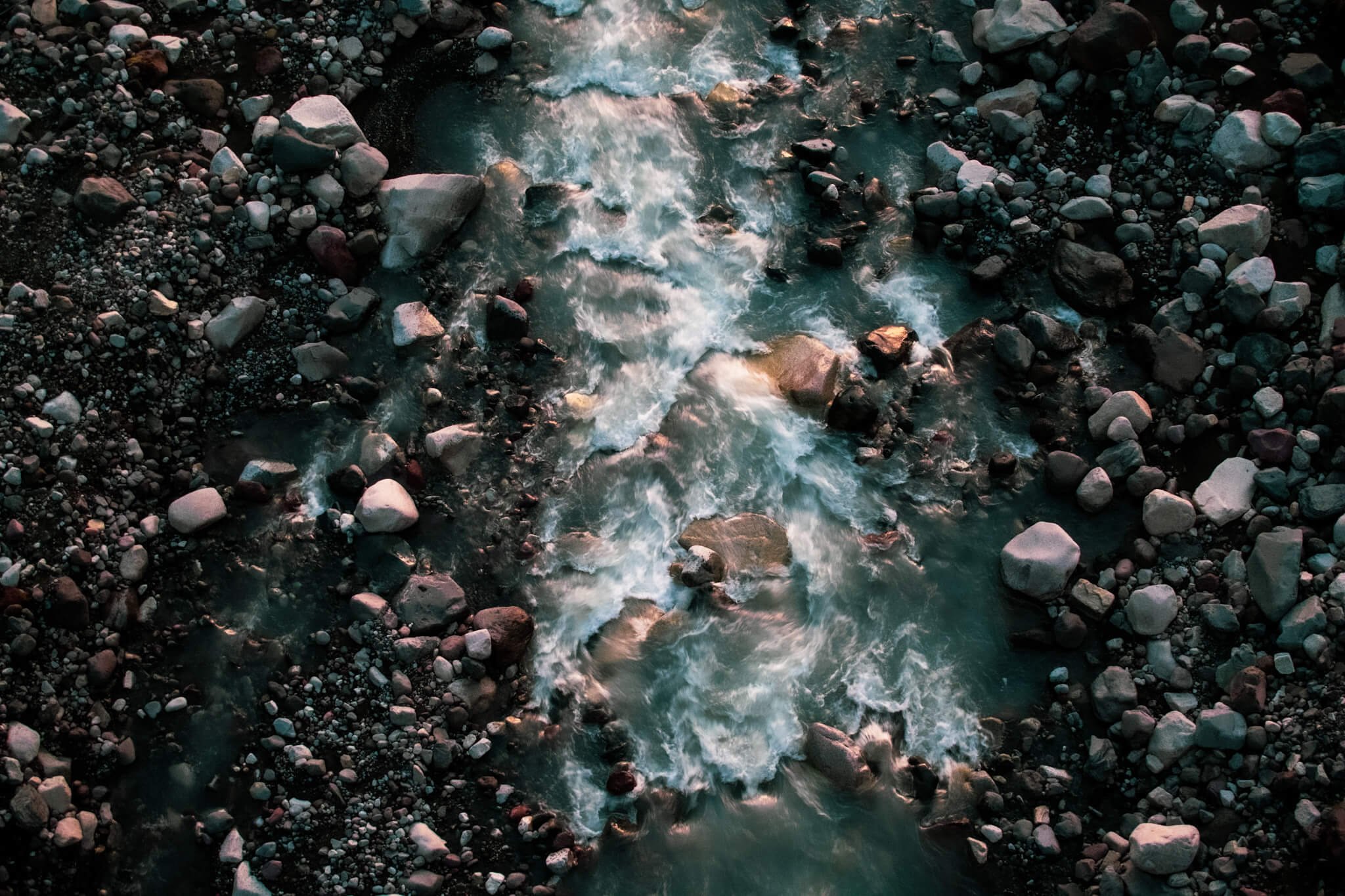 Golden hour, overhead photograph of a glacial river flowing through rocky riverbed, Washington State, USA, Pacific Northwest, Mount Rainier National Park.