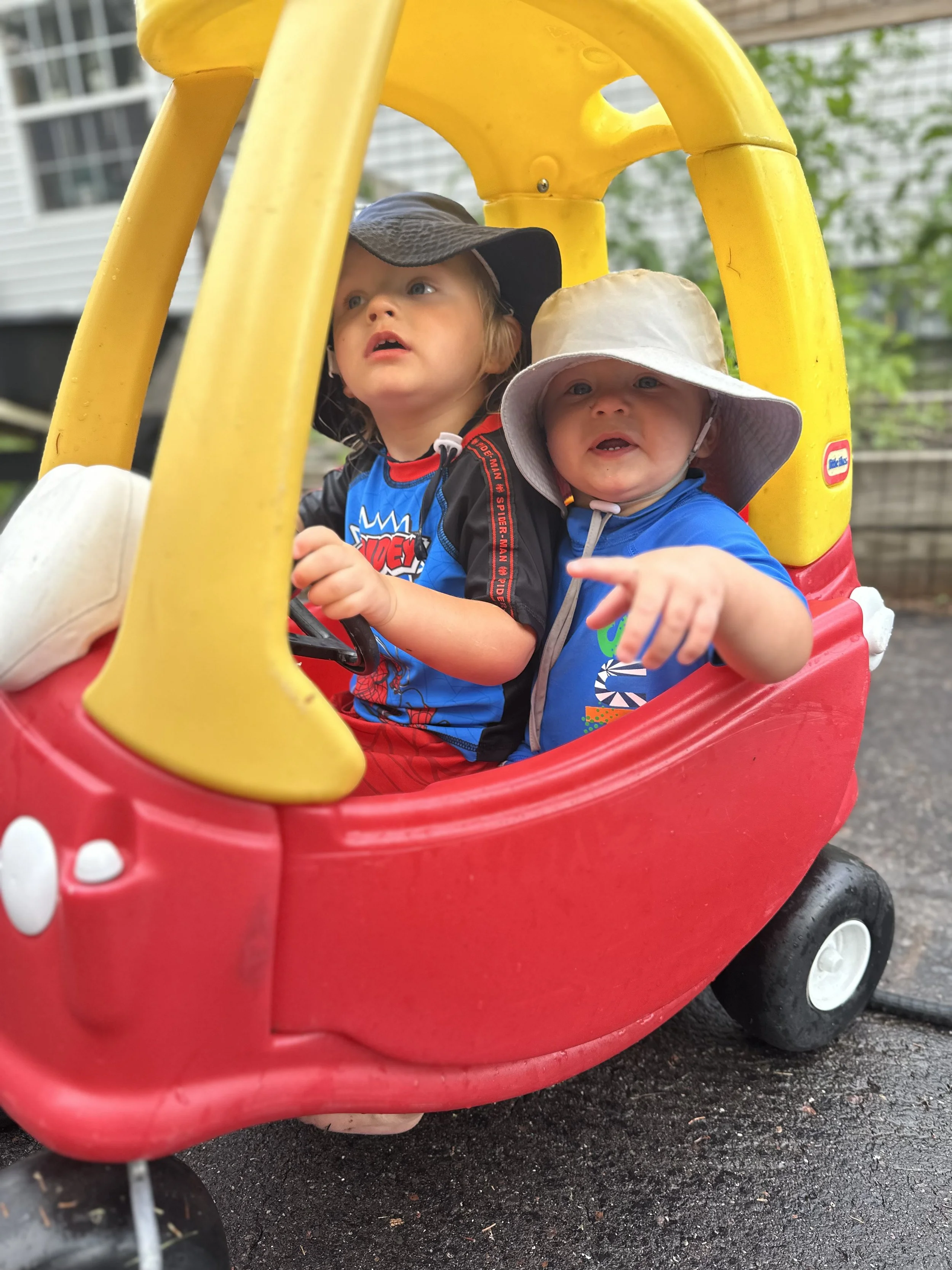 Brothers with sunhats riding little tyke care