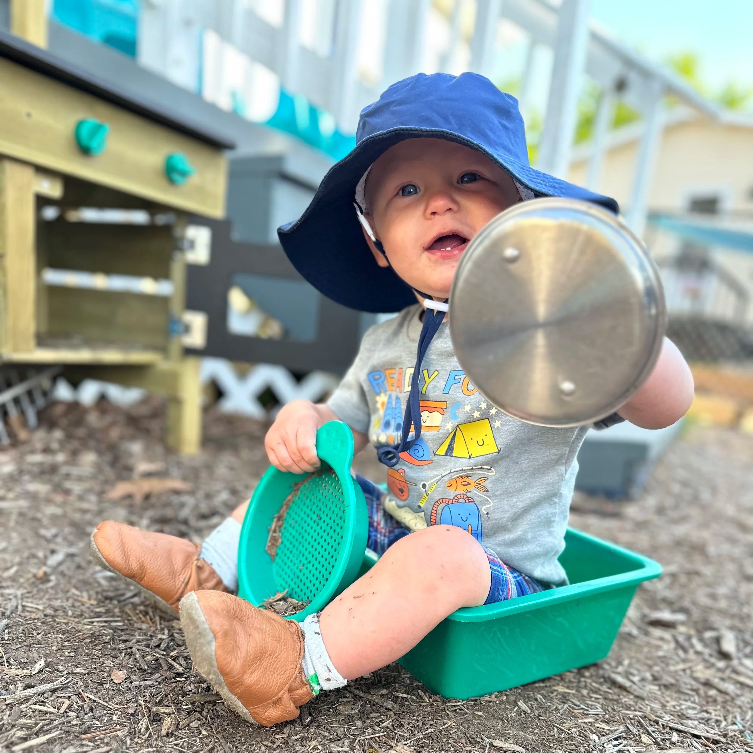 child playing in the outdoor mud kitchen at Kingdom Care Preschool