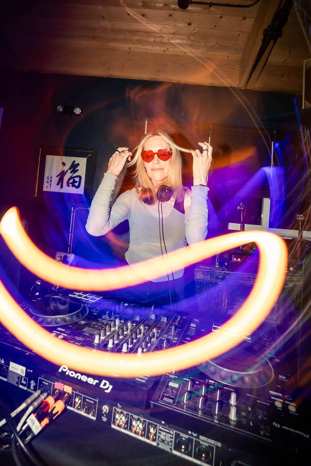 Tina DJing holding hair red glasses.jpg