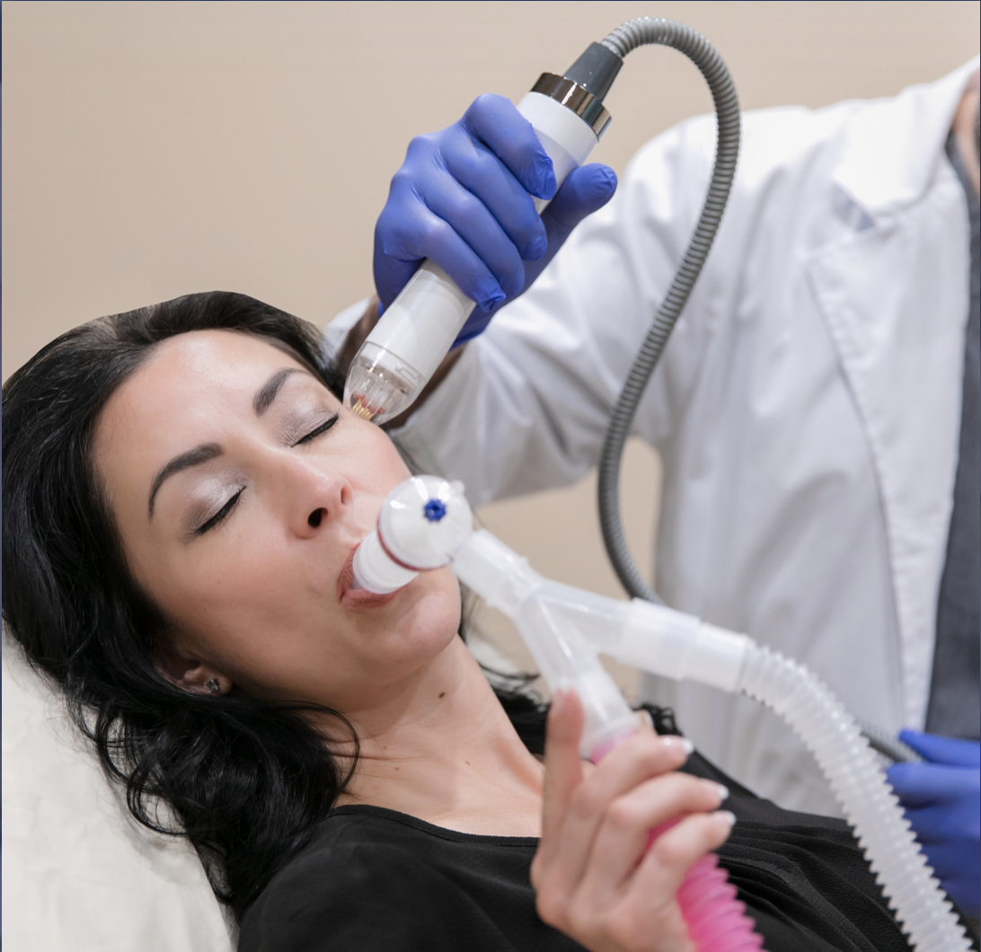Women holding ProNox tubing and mouthpiece to relieve pain and anxiety during laser procedure