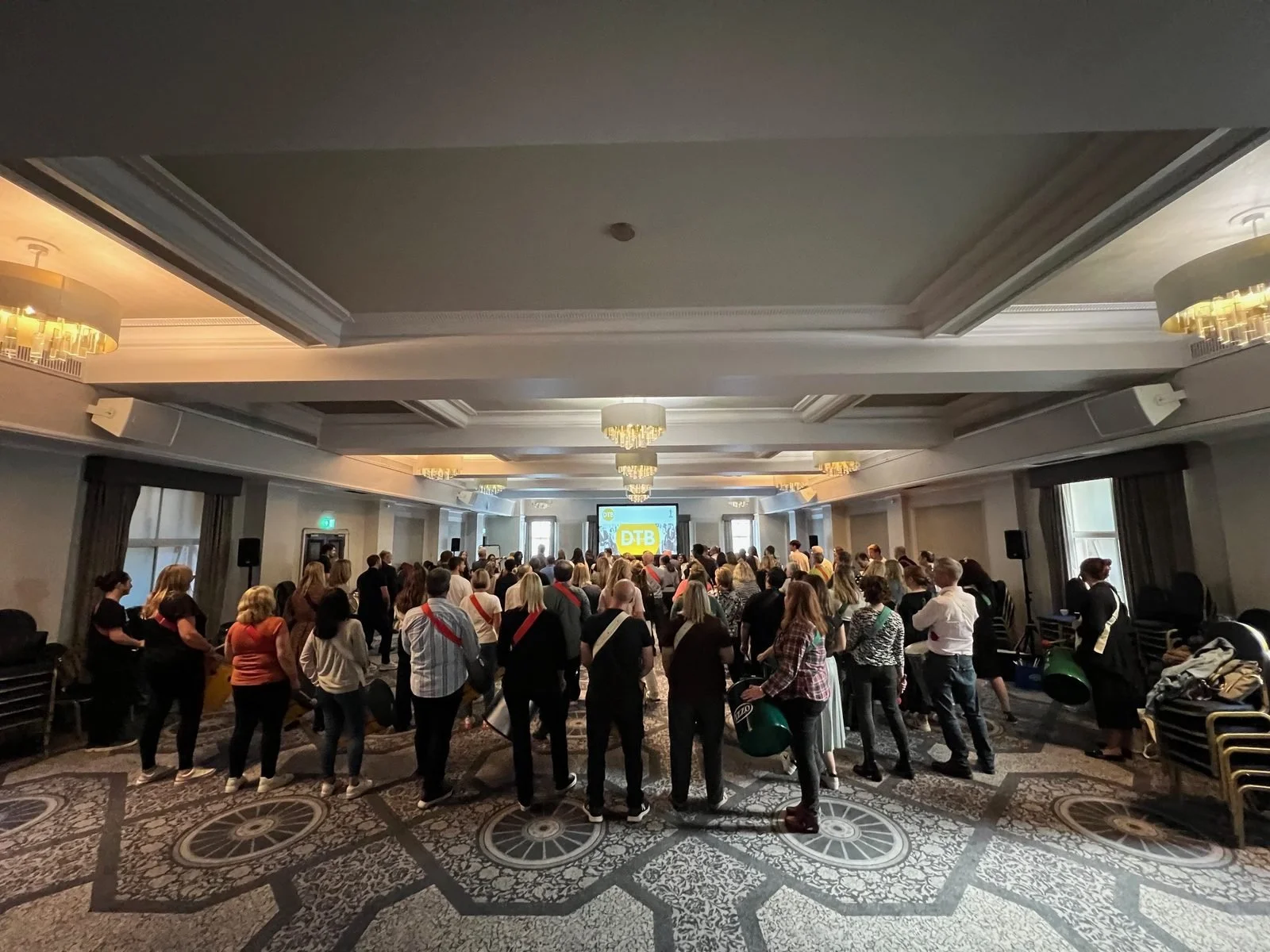 Conference guests in a hotel function room getting ready for a drumming team building session