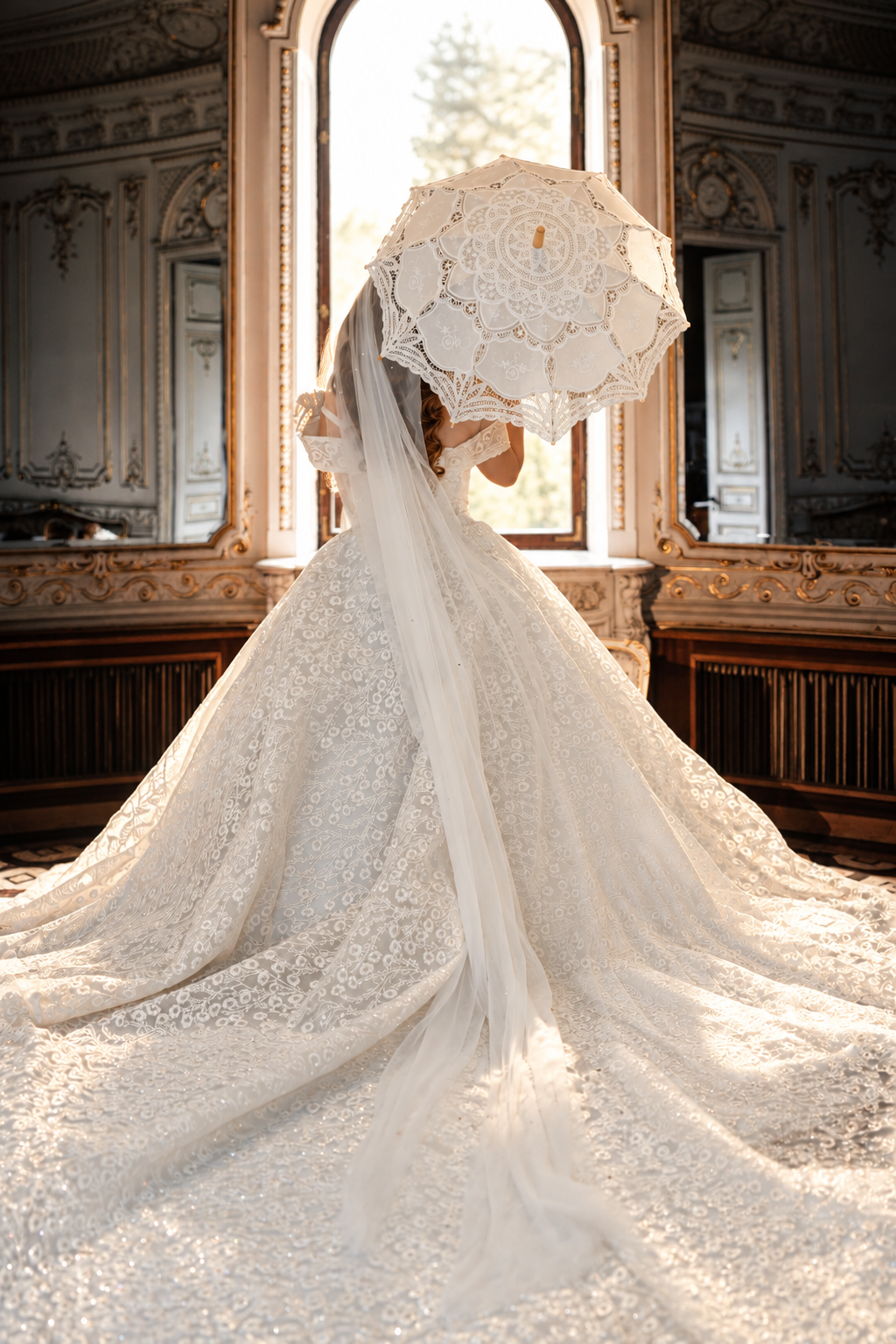 Bride in a white gown with a long train holding a bouquet in an elegant hall