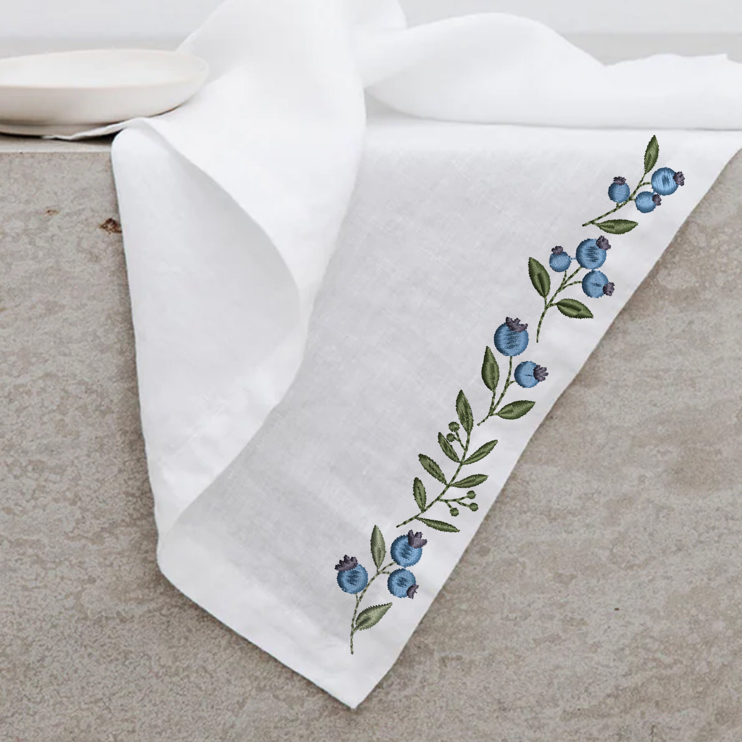Blueberry Wreath and Border Machine Embroidery Design File embroidered on a napkin trim