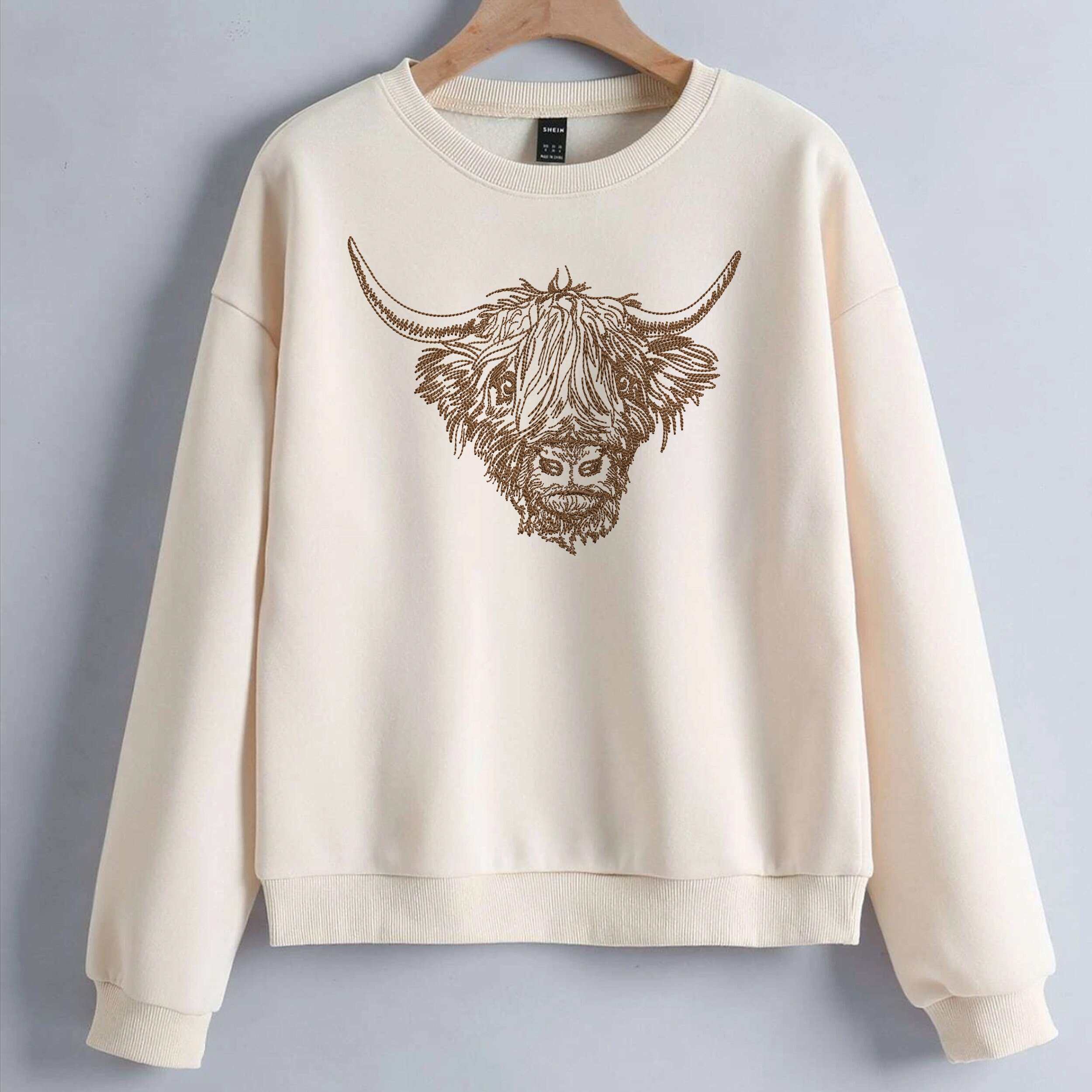 Scottish Highland Cow for Machine Embroidery embroidered on a sweater