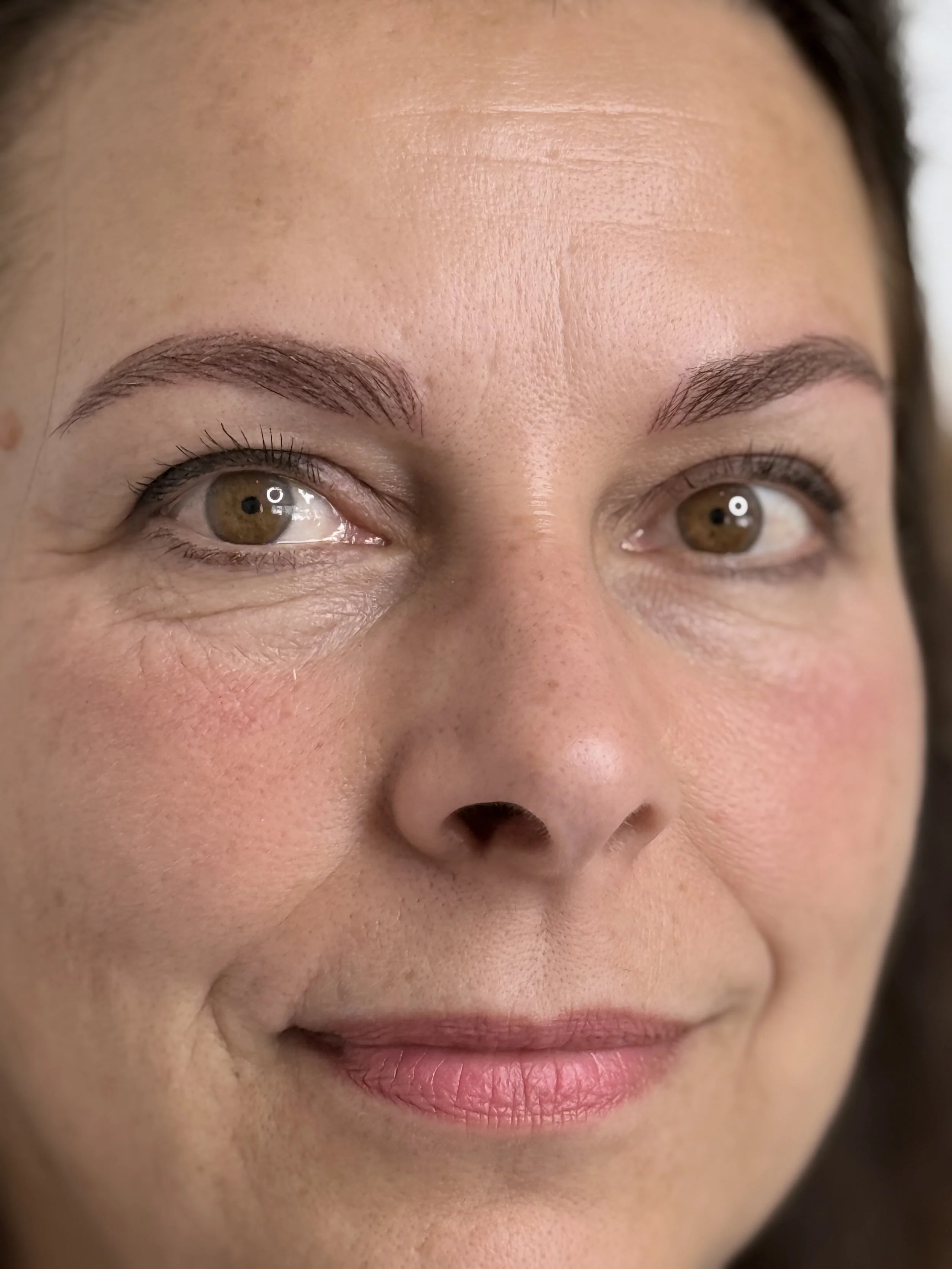 Nano Brows | Hyper-realism Brows Cambridge — Close-up of a woman's face showing her eyes, eyebrows, nose, and lips  — Cambridge Brow Sanctuary