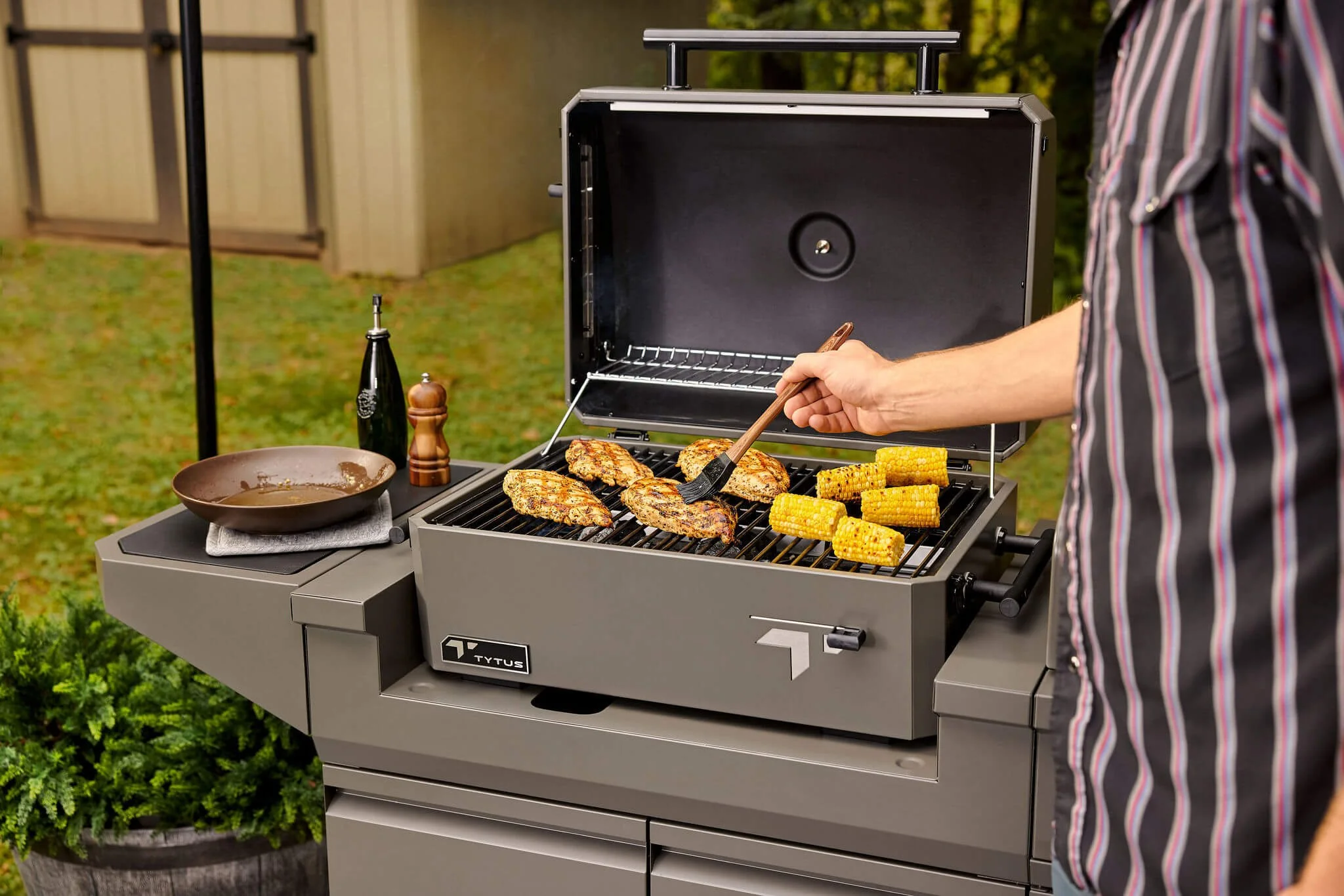 person brushing chicken on a grill