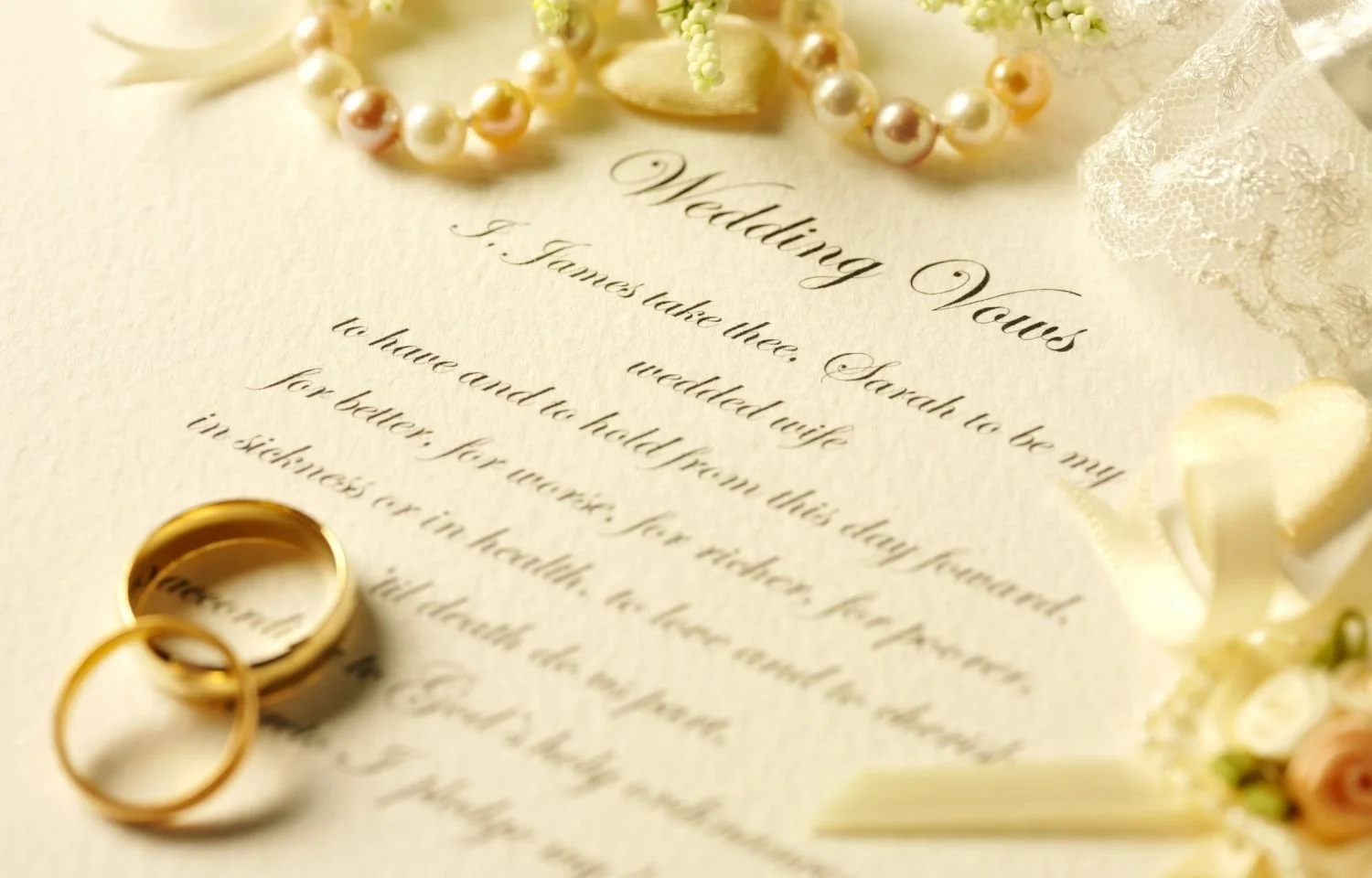 Closeup of wedding vows, gold rings, pearl necklace, and lace decor. Elegant marriage ceremony inspiration for planning heartfelt and memorable weddings.