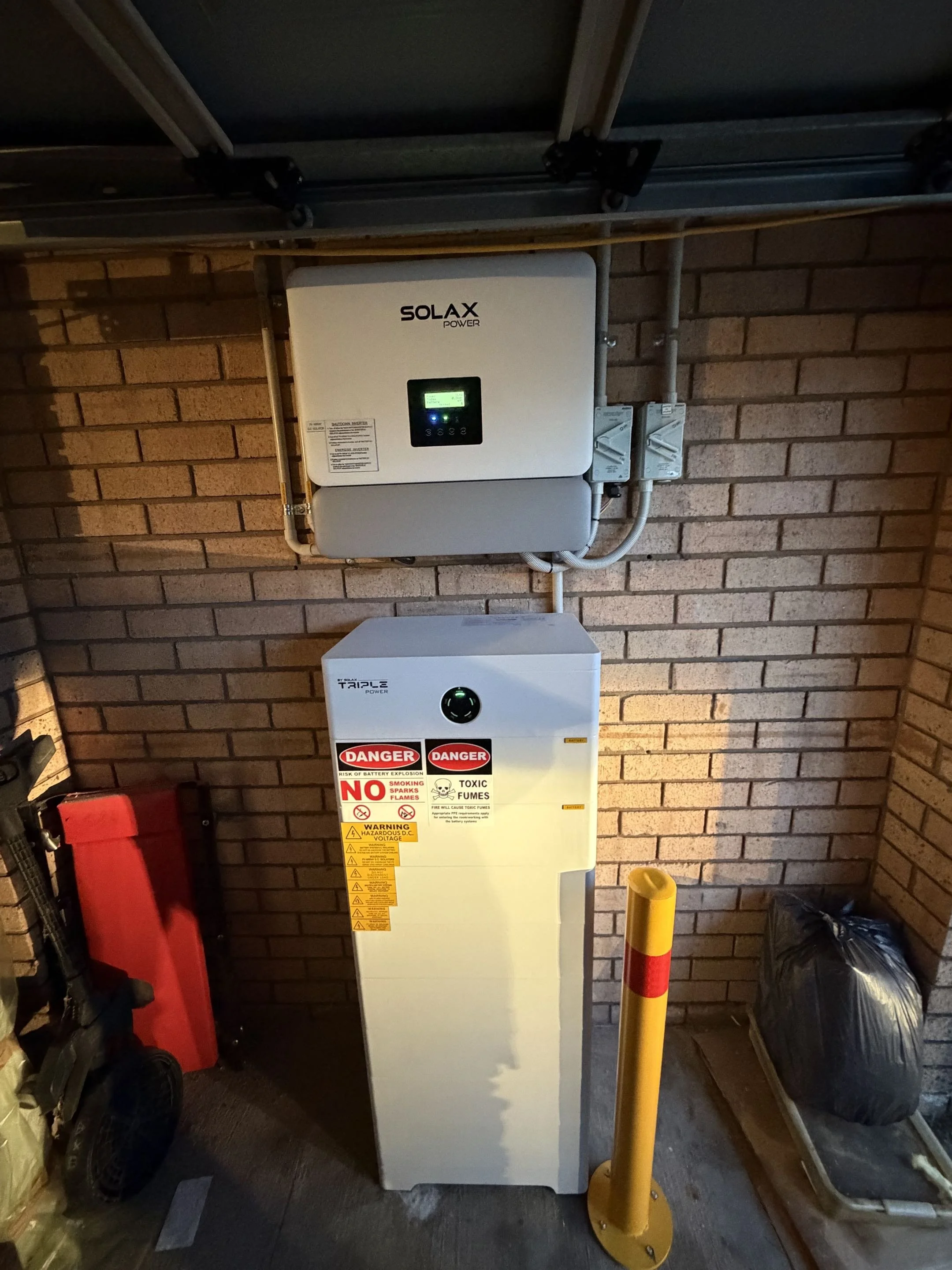 Solar battery with warning labels and connected to electrical conduits, surrounded by safety barriers and other tools.