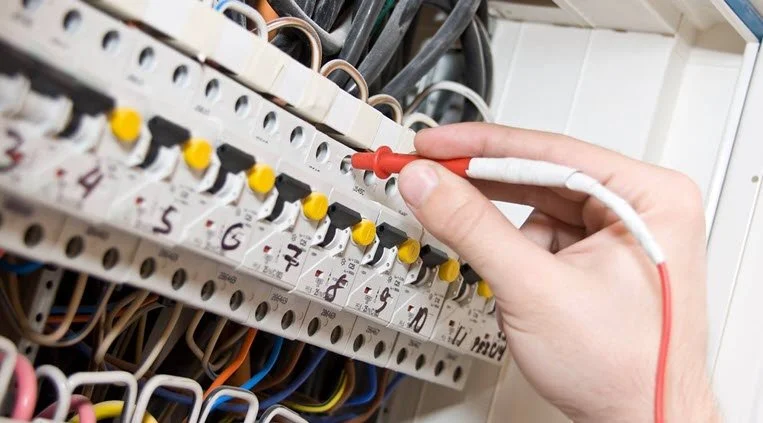 Electrician testing individual circuits inside a switchboard during electrical fault finding