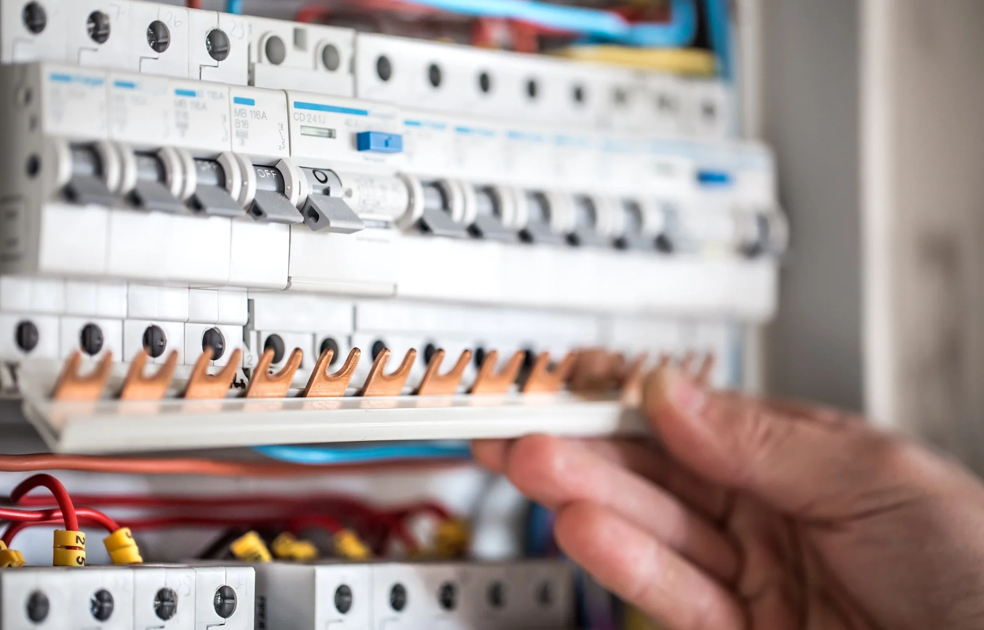 Electrician carrying out maintenance inside an electrical switchboard