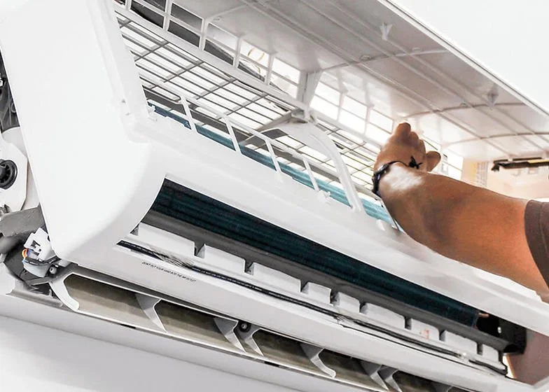 Technician inspecting the indoor unit of a wall-mounted split-system air conditioner