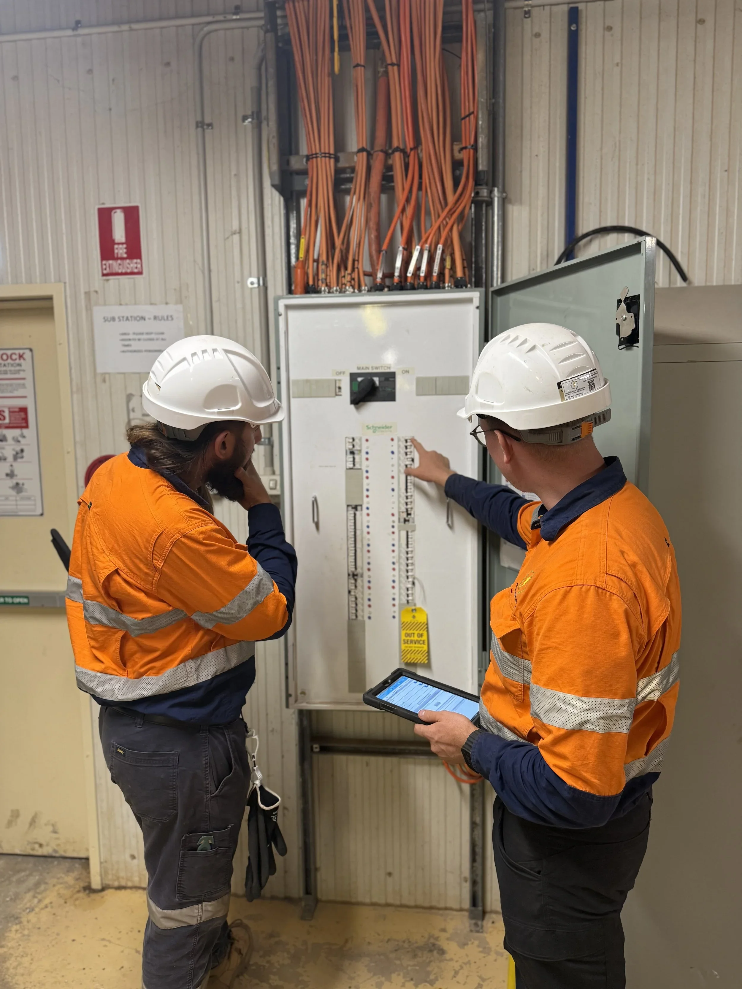Open industrial switchboard with circuit breakers and labelled electrical controls