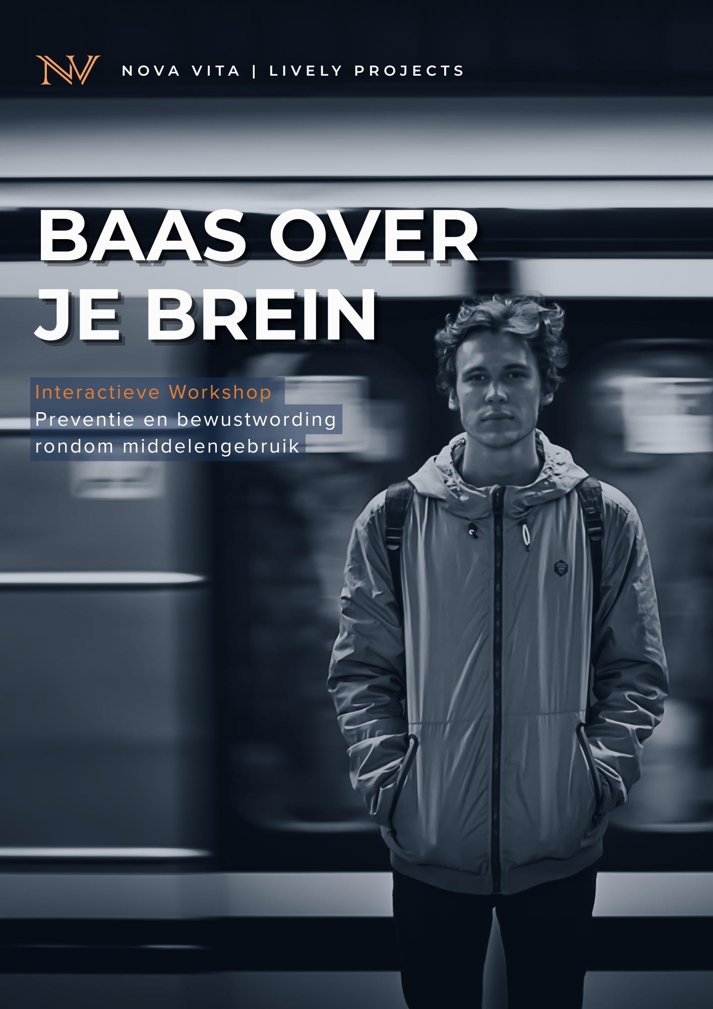 Een jonge man met een grijze jas en rugzak staat in een drukke ondergrondse hal met een trein op de achtergrond.