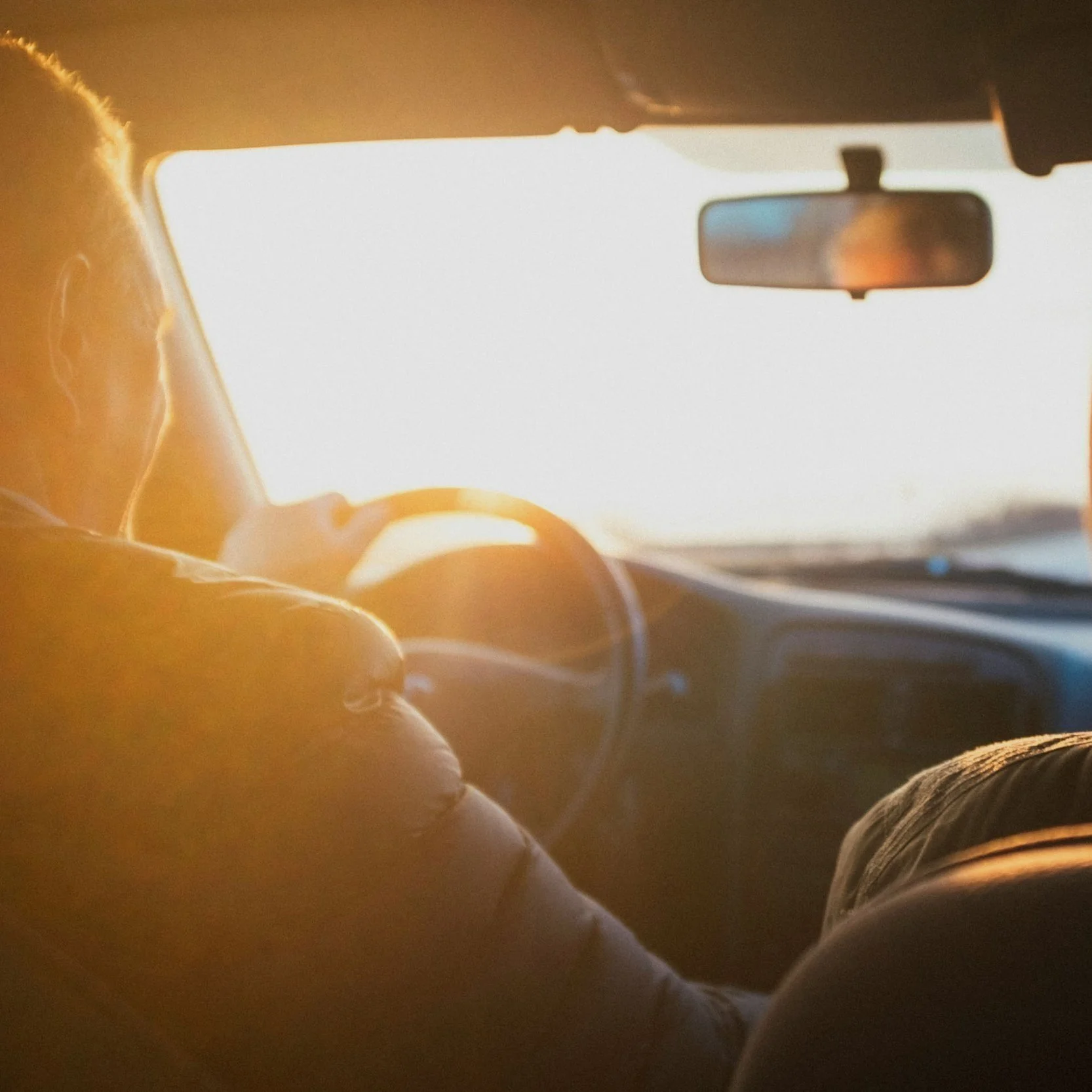 Driver in a car at sunset, representing Arra Finance's commitment to consumer success